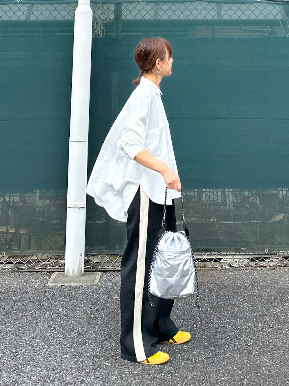 ホワイト系のシャツ/ブラウス、ブラック系のスラックス、シルバー系のショルダーバッグを着用したレディースの冬コーディネートの2枚目の写真