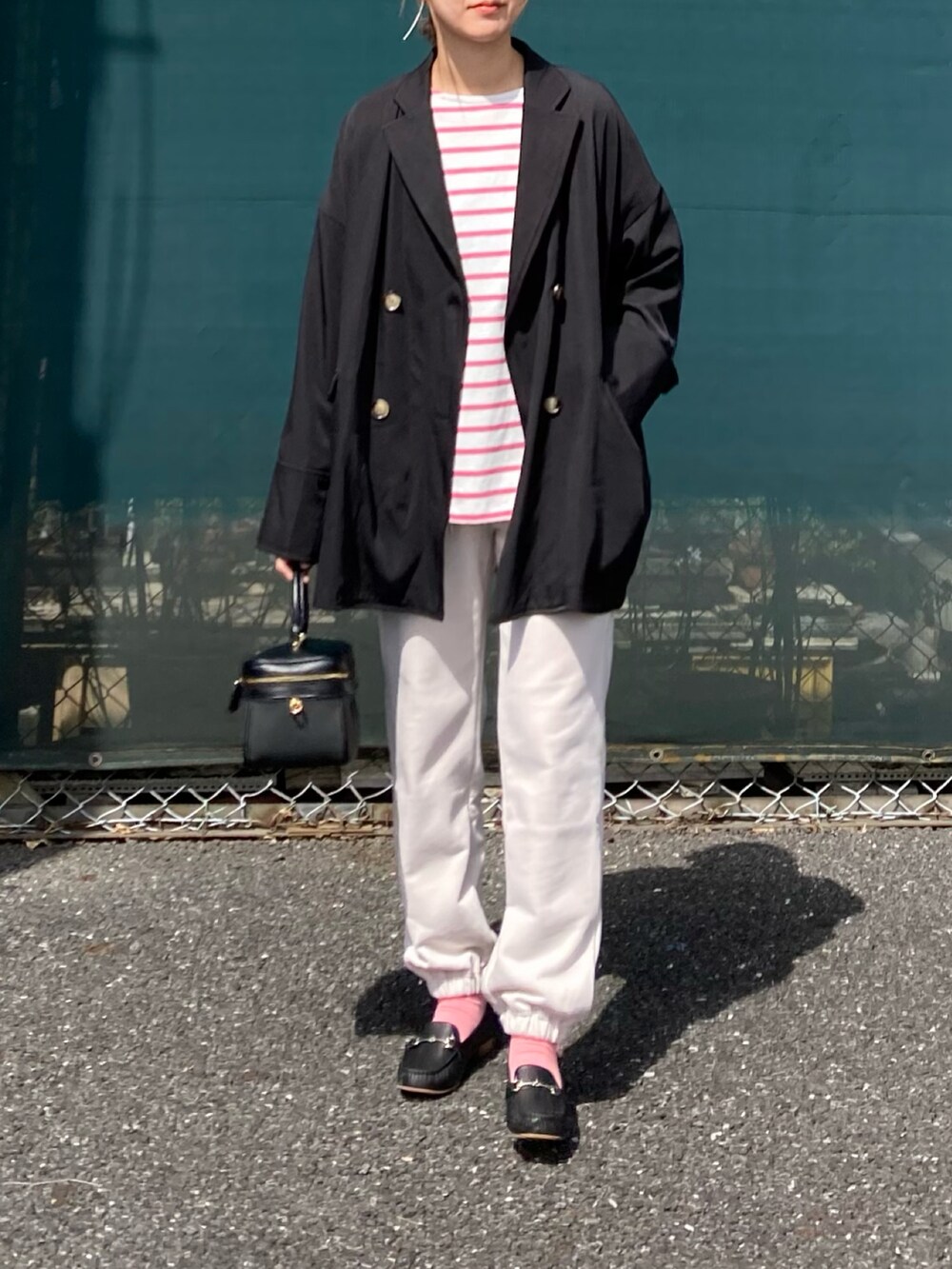 ホワイト系のTシャツ/カットソー、ブラック系のテーラードジャケット、ブラック系のショルダーバッグを着用したレディースの春コーディネートの4枚目の写真