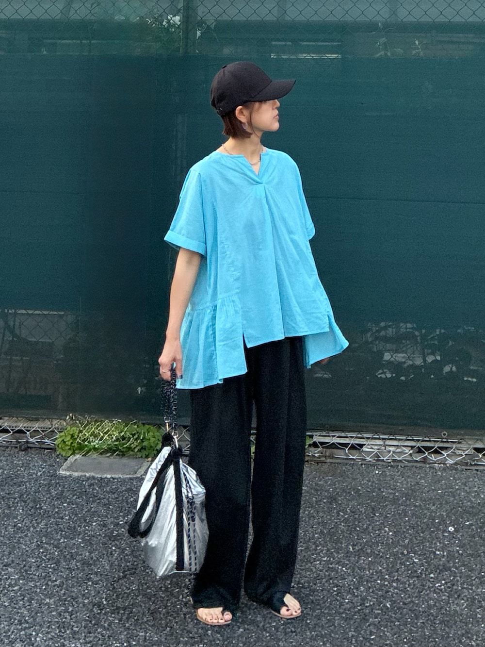 ブルー系のシャツ/ブラウス、ブラック系のスラックス、シルバー系のショルダーバッグを着用したレディースの夏コーディネートの2枚目の写真