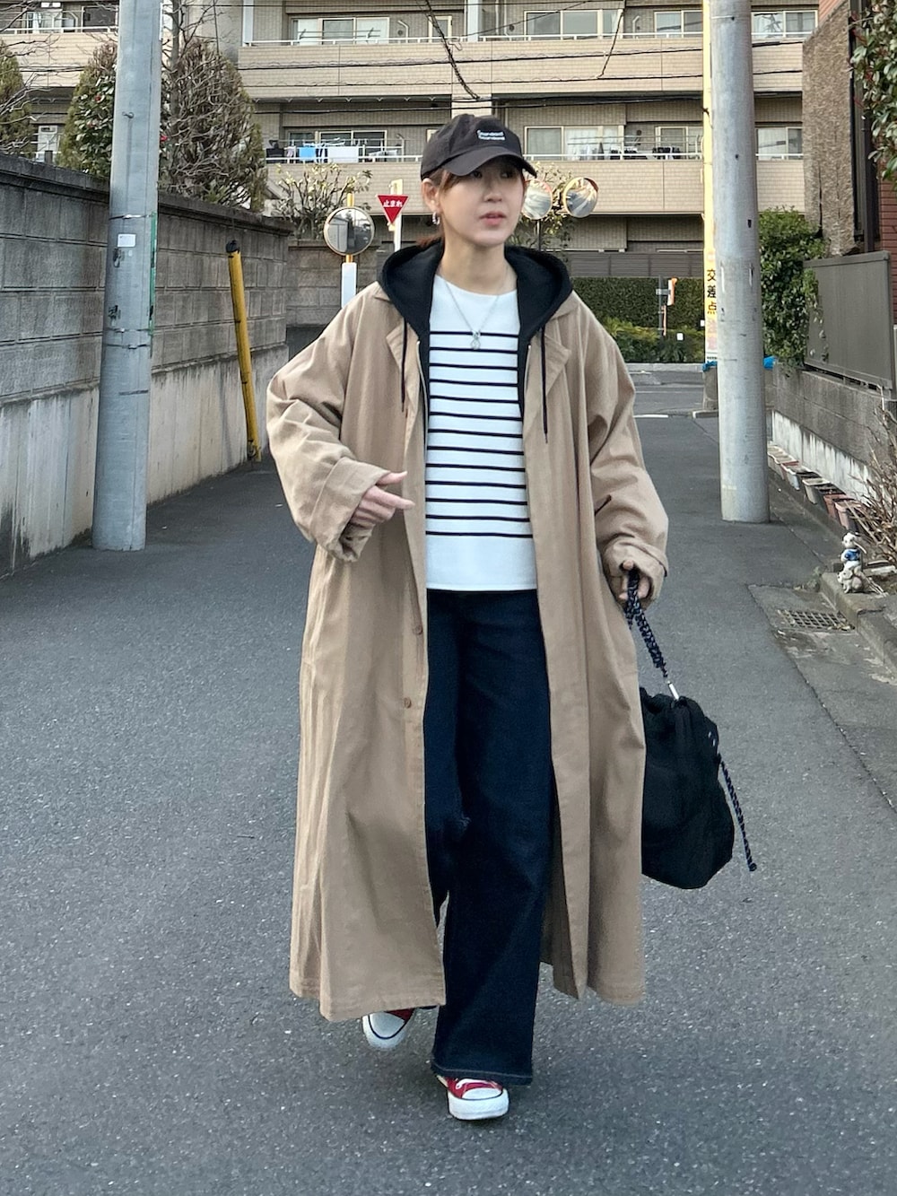 ホワイト系のニット/セーター、ブルー系のデニムパンツ、ブラック系のトートバッグを着用したレディースの春コーディネートの5枚目の写真