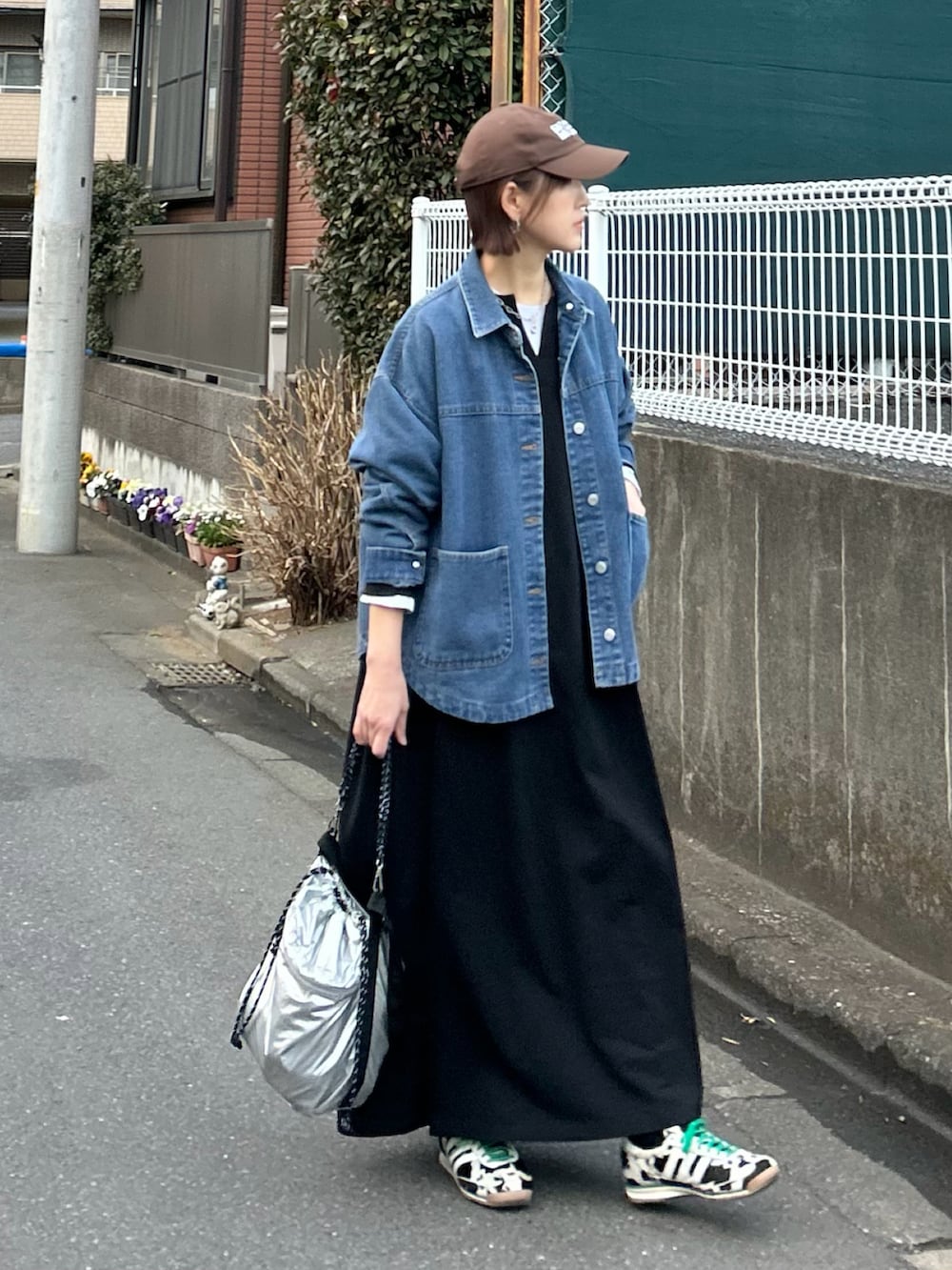 ブルー系のデニムジャケット、ブラック系のワンピース、シルバー系のトートバッグを着用したレディースの春コーディネートの2枚目の写真