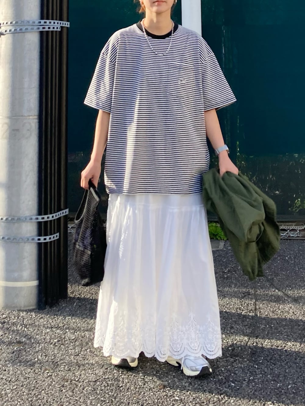 ブラック系のTシャツ/カットソー、ブルー系のデニムジャケット、ホワイト系のスカートを着用したレディースの春コーディネートの4枚目の写真