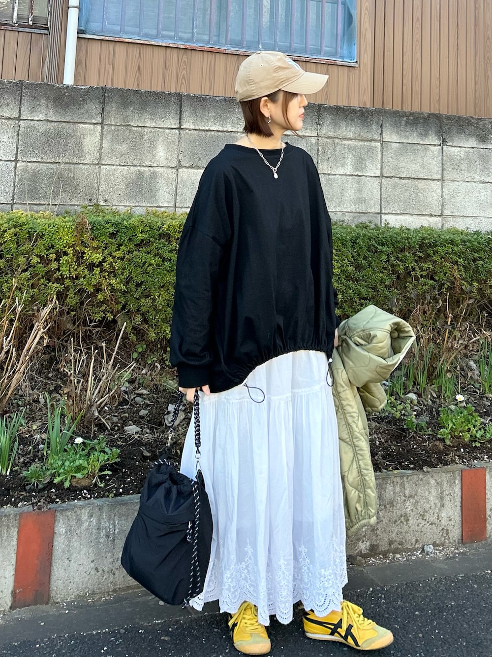 ホワイト系のスカート、シルバー系のトートバッグ、ブラック系のTシャツ/カットソーを着用したレディースの冬コーディネートの2枚目の写真