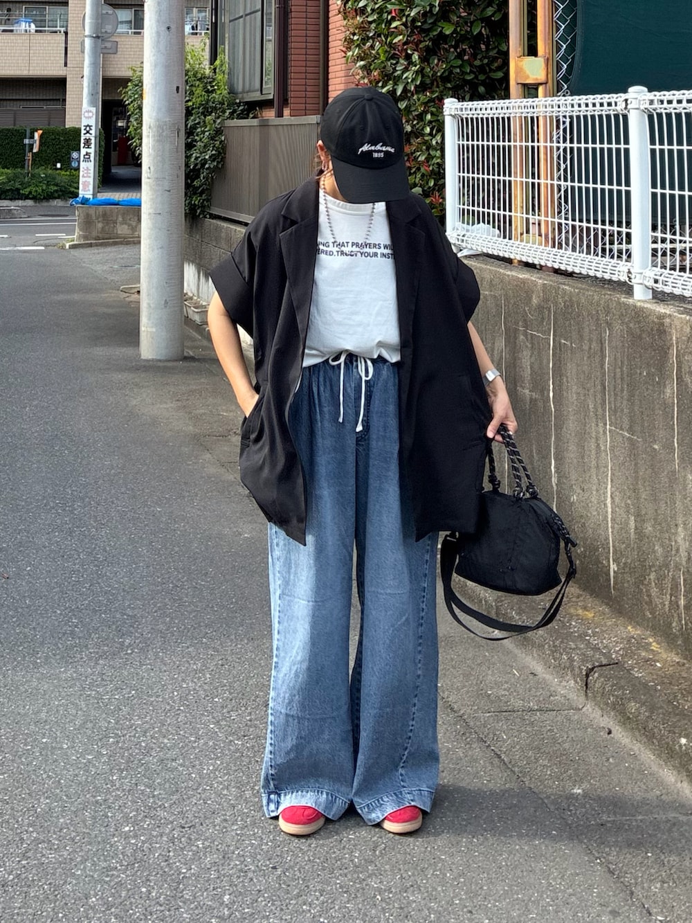ブラック系のテーラードジャケット、ホワイト系のTシャツ/カットソー、ブラック系のトートバッグを着用したレディースの夏コーディネートの4枚目の写真