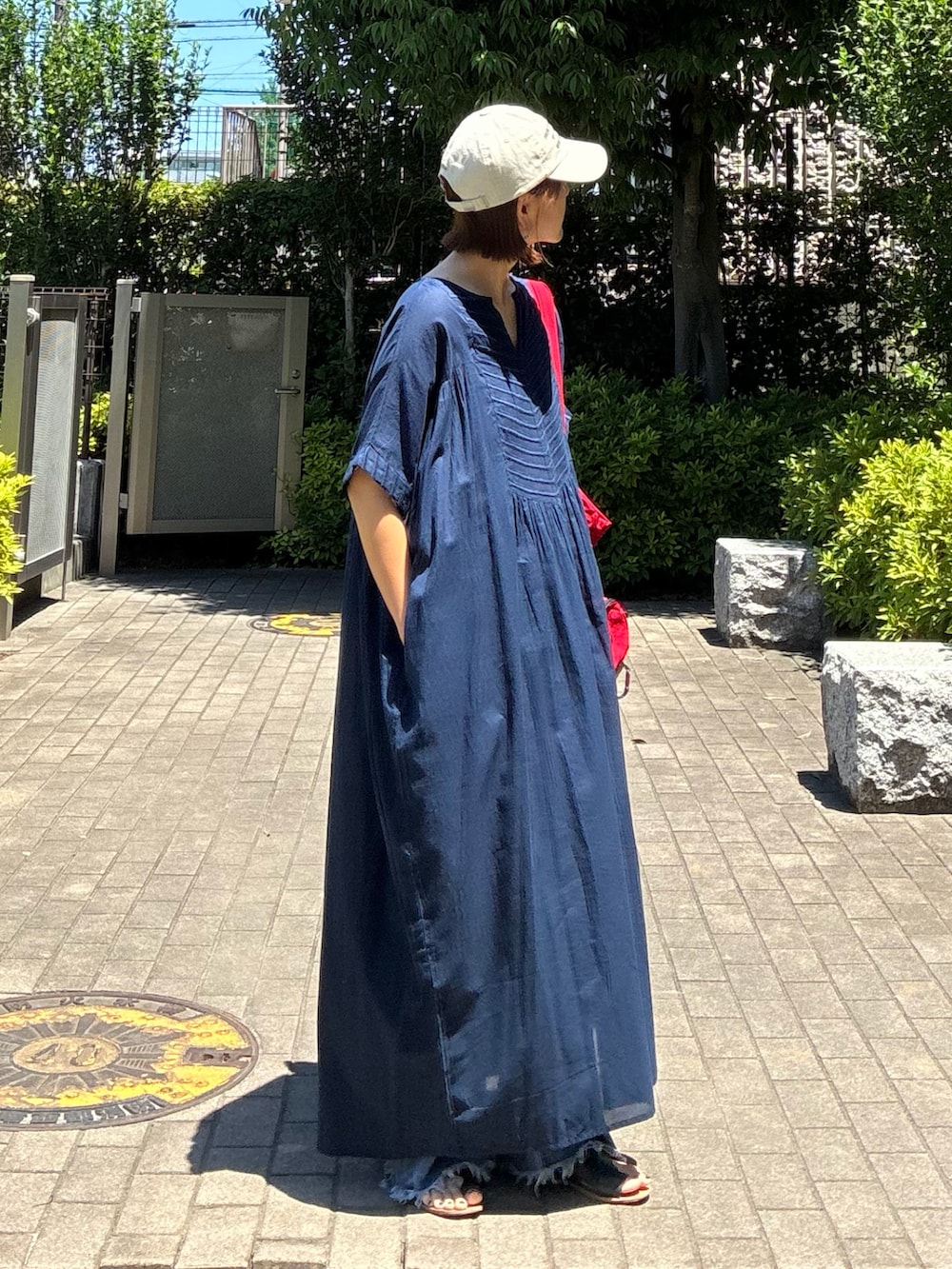 ブルー系のデニムパンツ、レッド系のトートバッグ、ブルー系のワンピースを着用したレディースの夏コーディネートの3枚目の写真