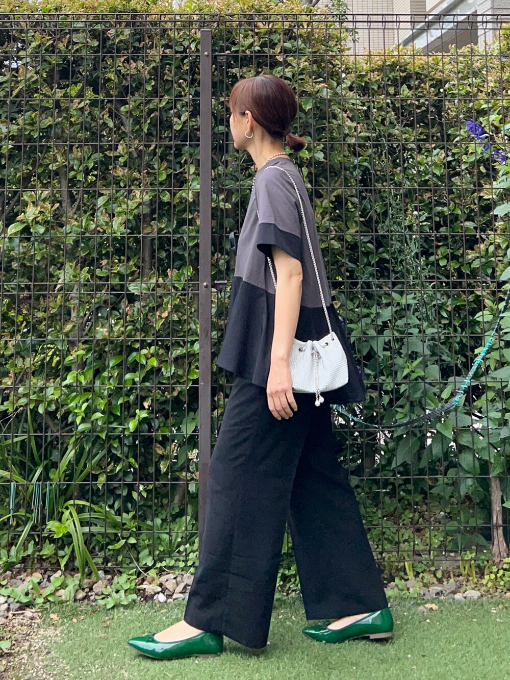 グレー系のTシャツ/カットソー、ブラック系のその他パンツ、ホワイト系のショルダーバッグを着用したレディースの春コーディネートの3枚目の写真