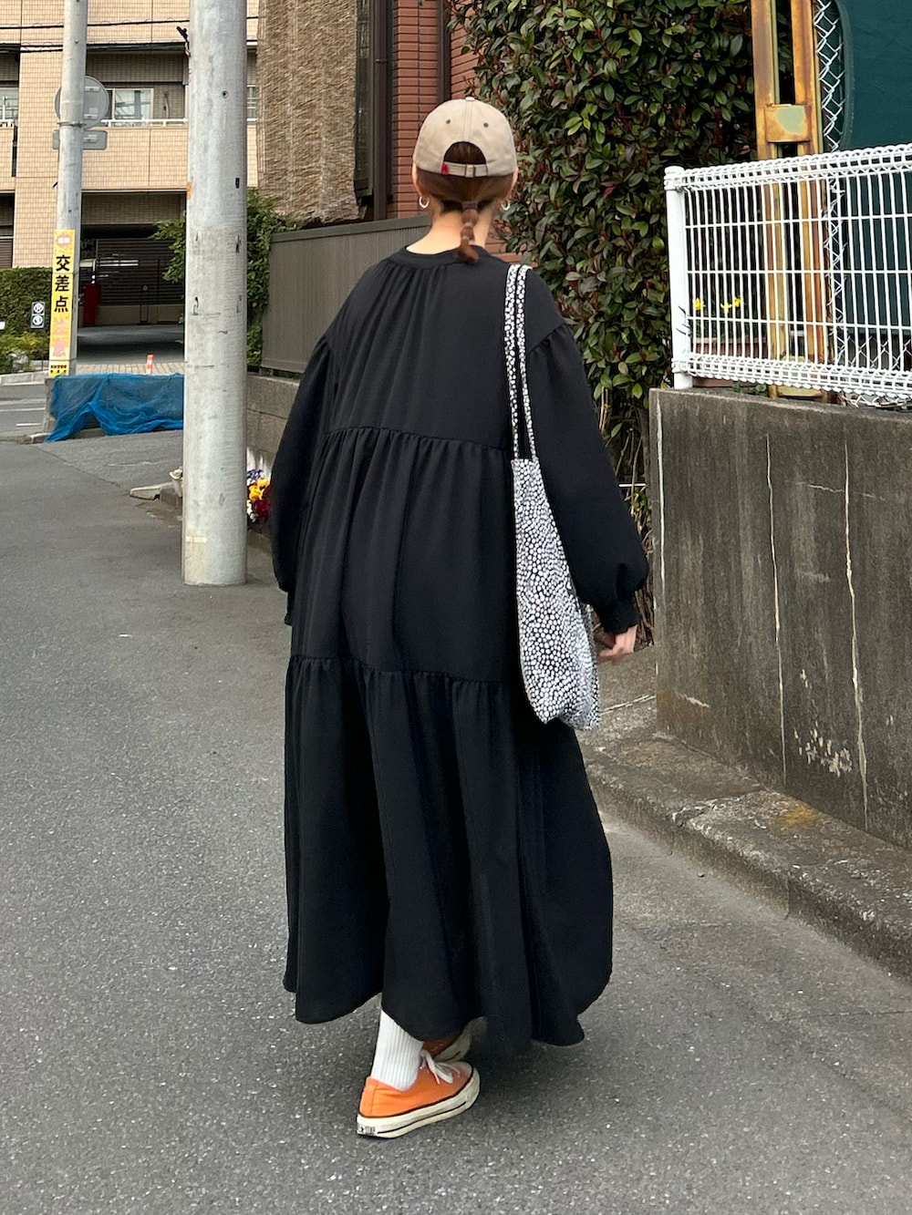 ブラック系のシャツワンピース、ブラック系のトートバッグ、ベージュ系のキャップを着用したレディースの春コーディネートの4枚目の写真