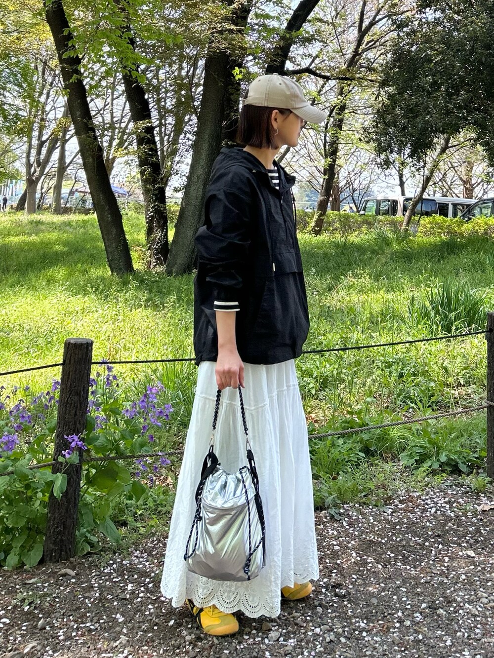 ブラック系のブルゾン、ブラック系のTシャツ/カットソー、ホワイト系のスカートを着用したレディースの春コーディネートの3枚目の写真