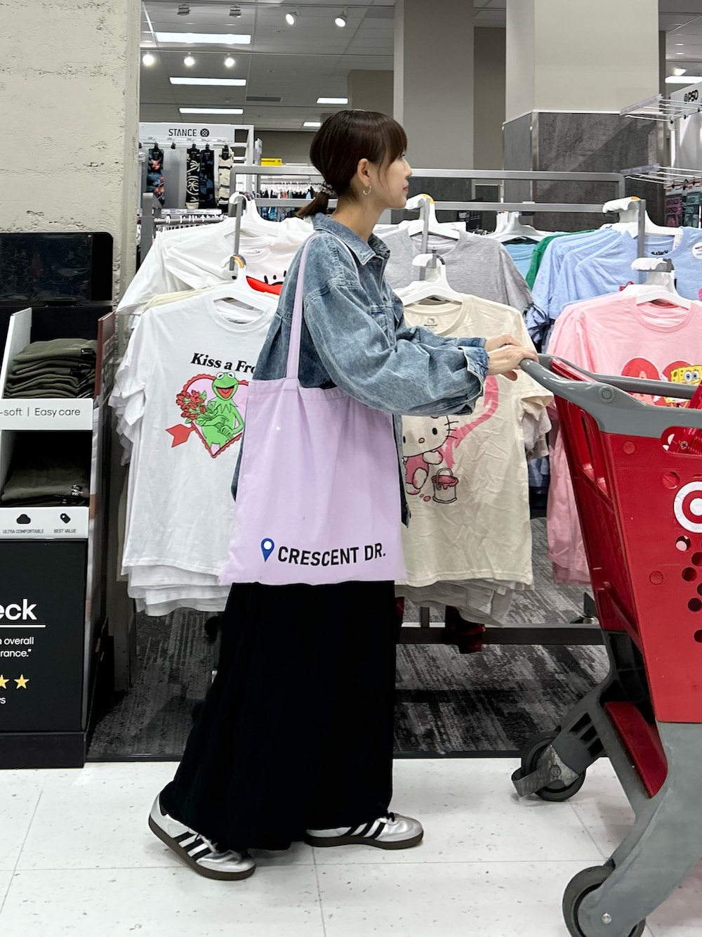 ブラック系のワンピース、ブルー系のデニムジャケット、パープル系のトートバッグを着用したレディースの春コーディネートの3枚目の写真