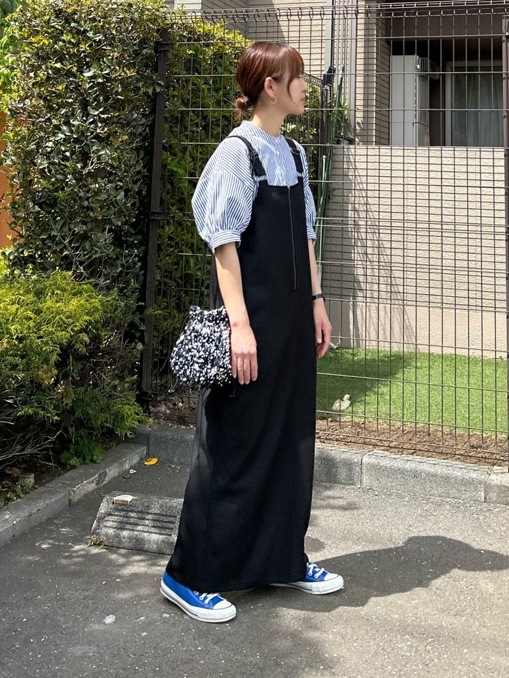 ブルー系のシャツ/ブラウス、ブラック系のワンピース、シルバー系のハンドバッグを着用したレディースの春コーディネートの2枚目の写真