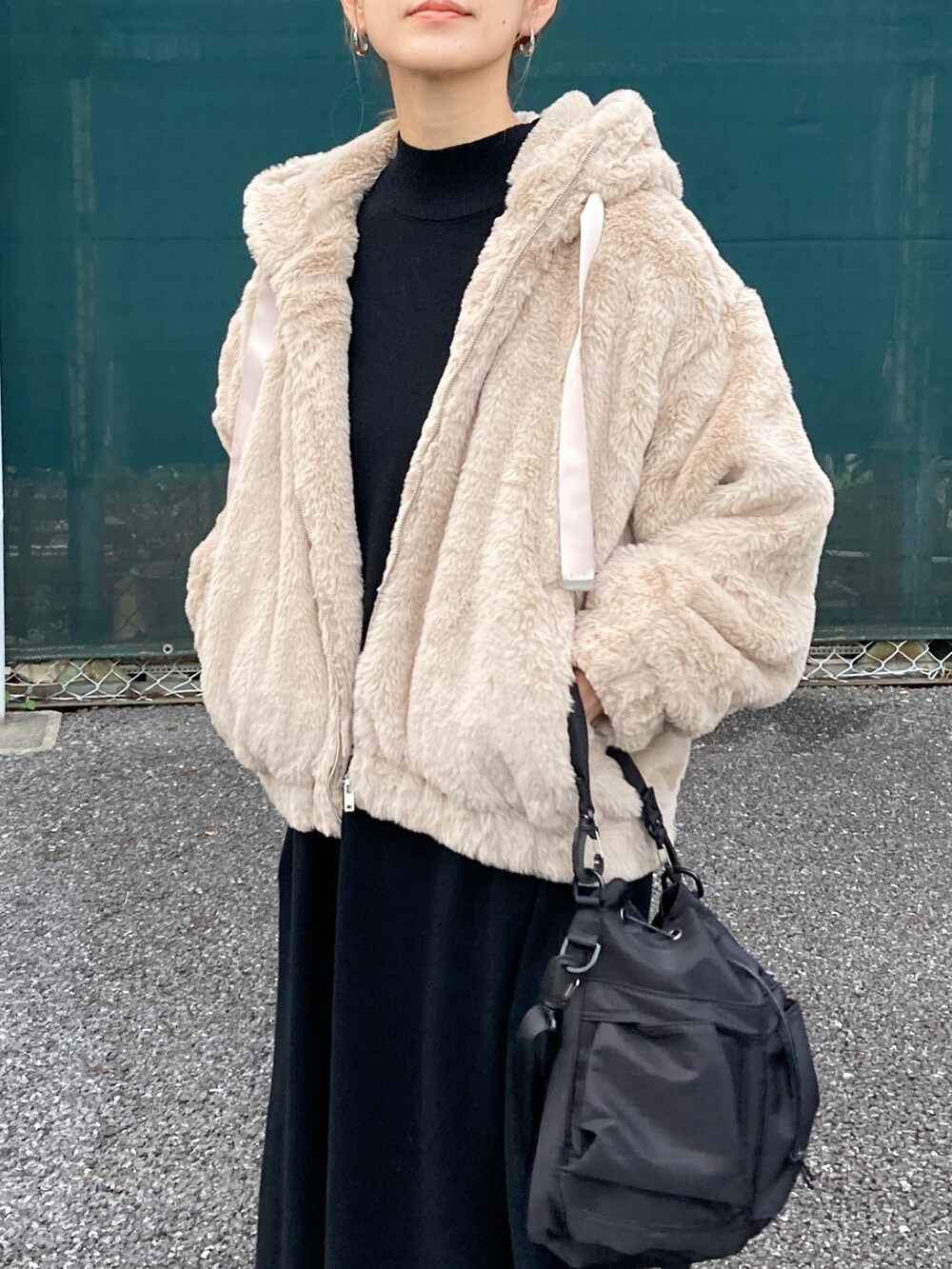 ベージュ系のブルゾン、ブラック系のワンピース、ブラック系のショルダーバッグを着用したレディースの秋コーディネートの2枚目の写真