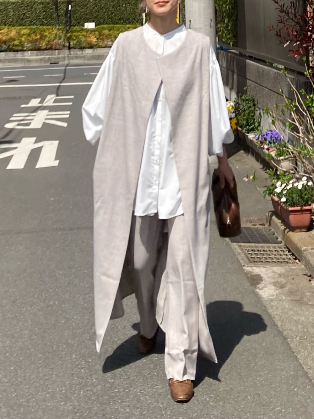 ホワイト系のシャツ/ブラウス、ベージュ系のベスト、ベージュ系のスラックスを着用したレディースの春コーディネートの5枚目の写真