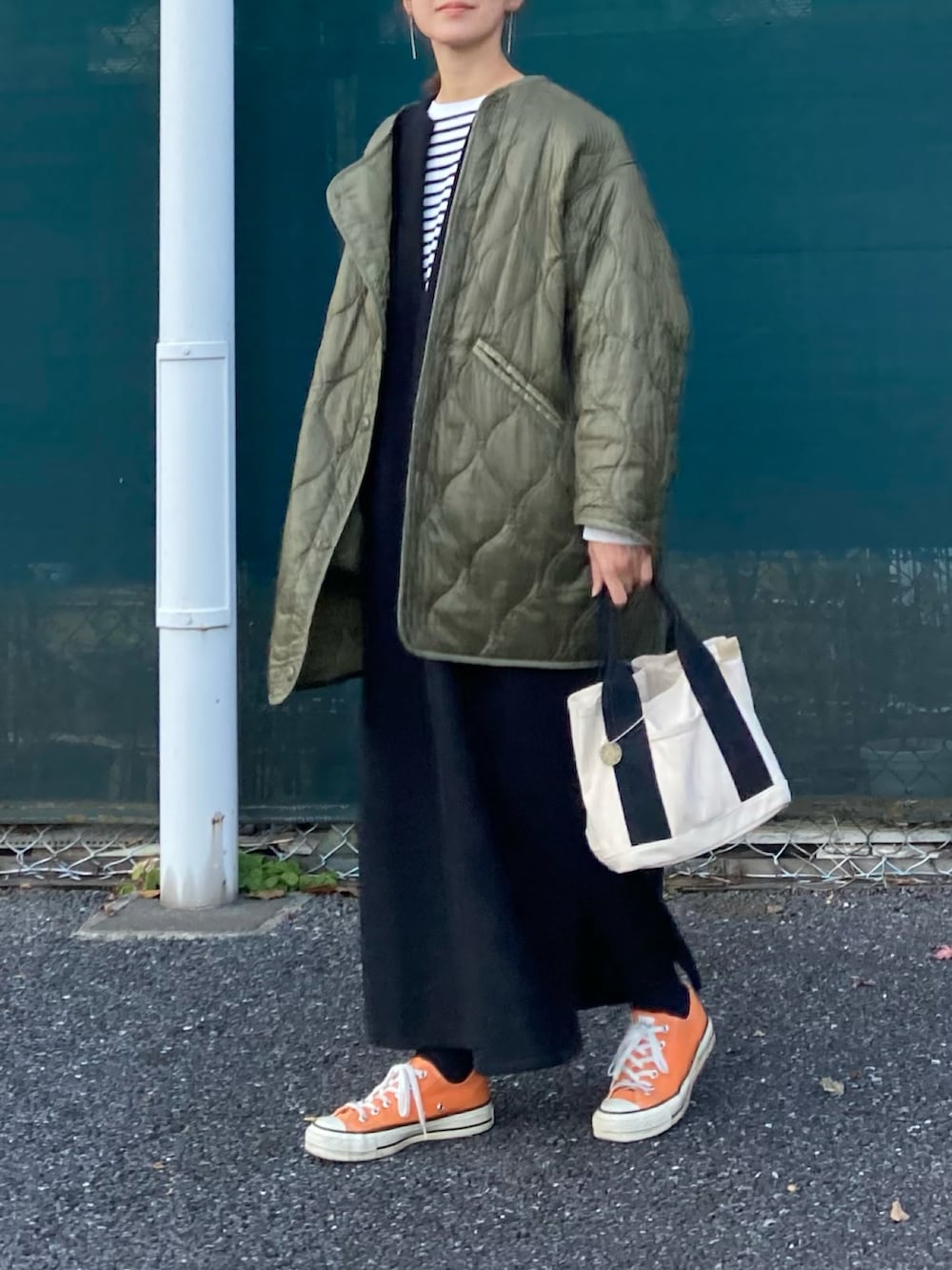 グリーン系のノーカラージャケット、ブラック系のワンピース、ブラック系のTシャツ/カットソーを着用したレディースの冬コーディネートの2枚目の写真