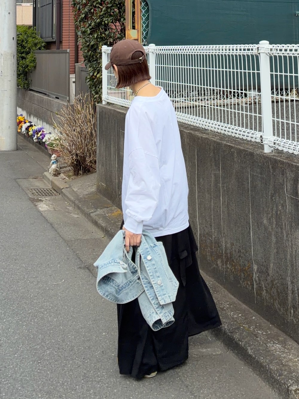 ホワイト系のTシャツ/カットソー、ブラック系のスカート、シルバー系のトートバッグを着用したレディースの春コーディネートの4枚目の写真