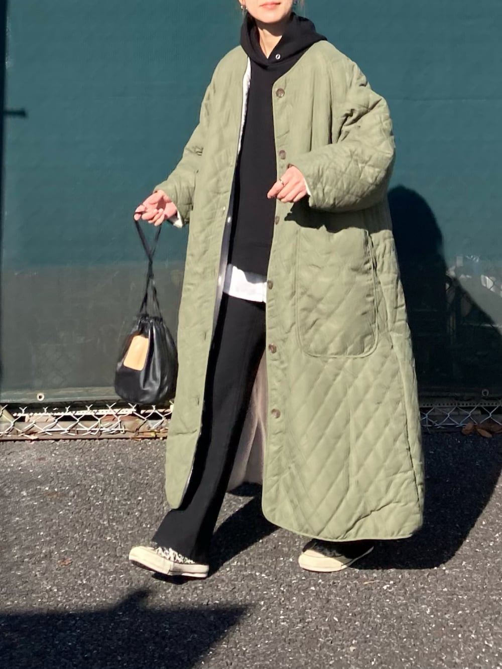 グリーン系のダウンジャケット/コート、ブラック系のパーカー、ブラック系のその他パンツを着用したレディースの冬コーディネートの2枚目の写真