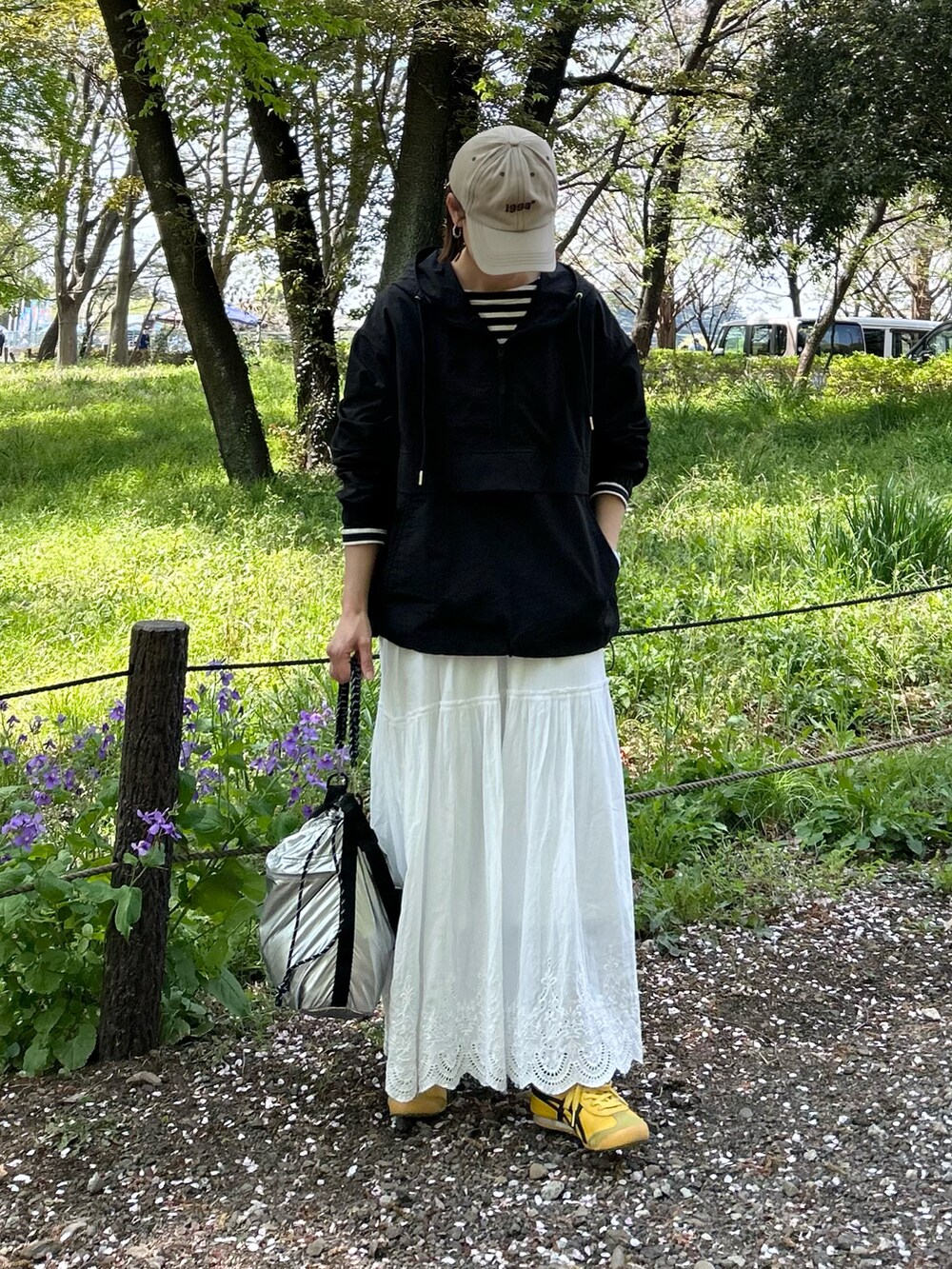 ブラック系のブルゾン、ブラック系のTシャツ/カットソー、ホワイト系のスカートを着用したレディースの春コーディネートの5枚目の写真