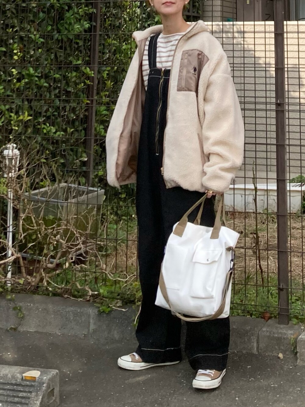 ベージュ系のブルゾン、ベージュ系のTシャツ/カットソー、ブラック系のサロペット/オーバーオールを着用したレディースの秋コーディネートの2枚目の写真