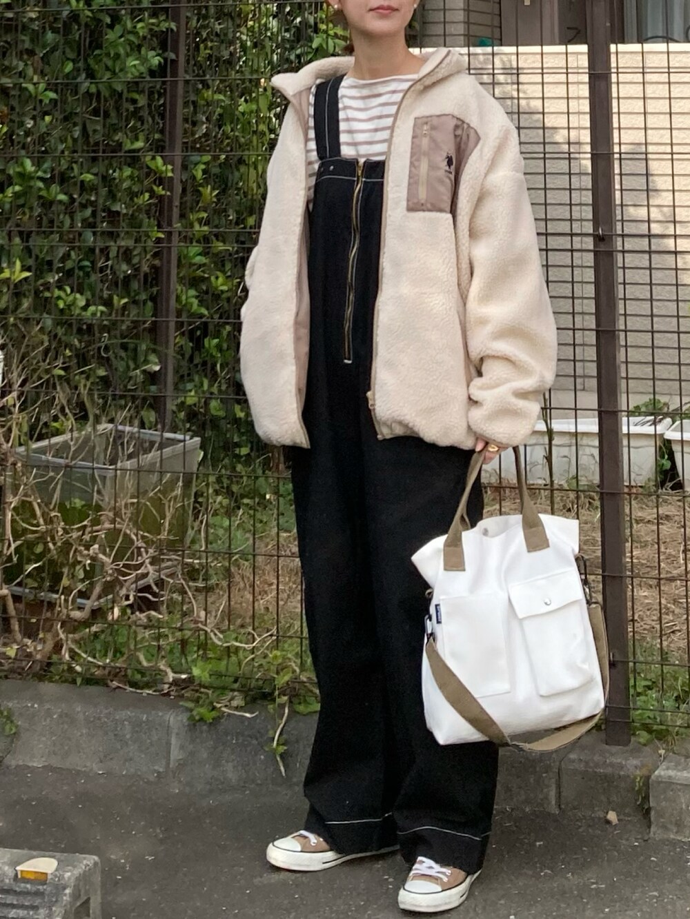ベージュ系のブルゾン、ベージュ系のTシャツ/カットソー、ブラック系のサロペット/オーバーオールを着用したレディースの秋コーディネートの3枚目の写真
