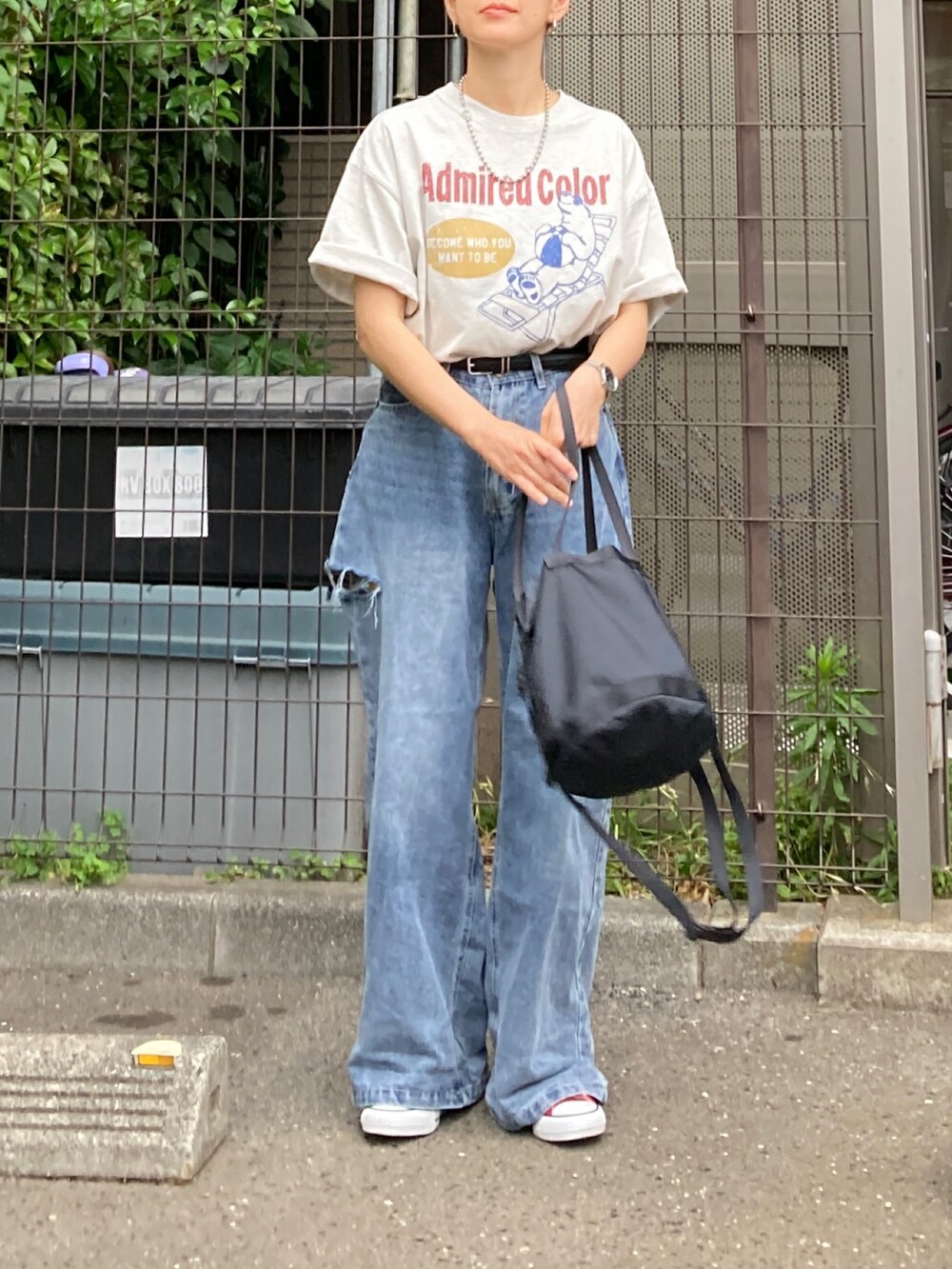 ベージュ系のTシャツ/カットソー、ブルー系のデニムパンツ、ブラック系のバッグを着用したレディースの夏コーディネートの3枚目の写真