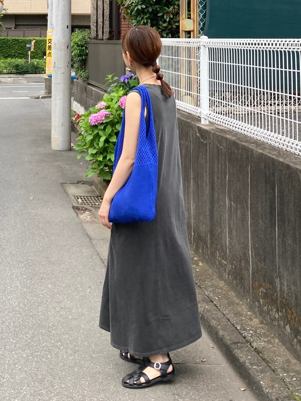グレー系のワンピース、ブルー系のショルダーバッグ、ブラック系のサンダルを着用したレディースの夏コーディネートの5枚目の写真