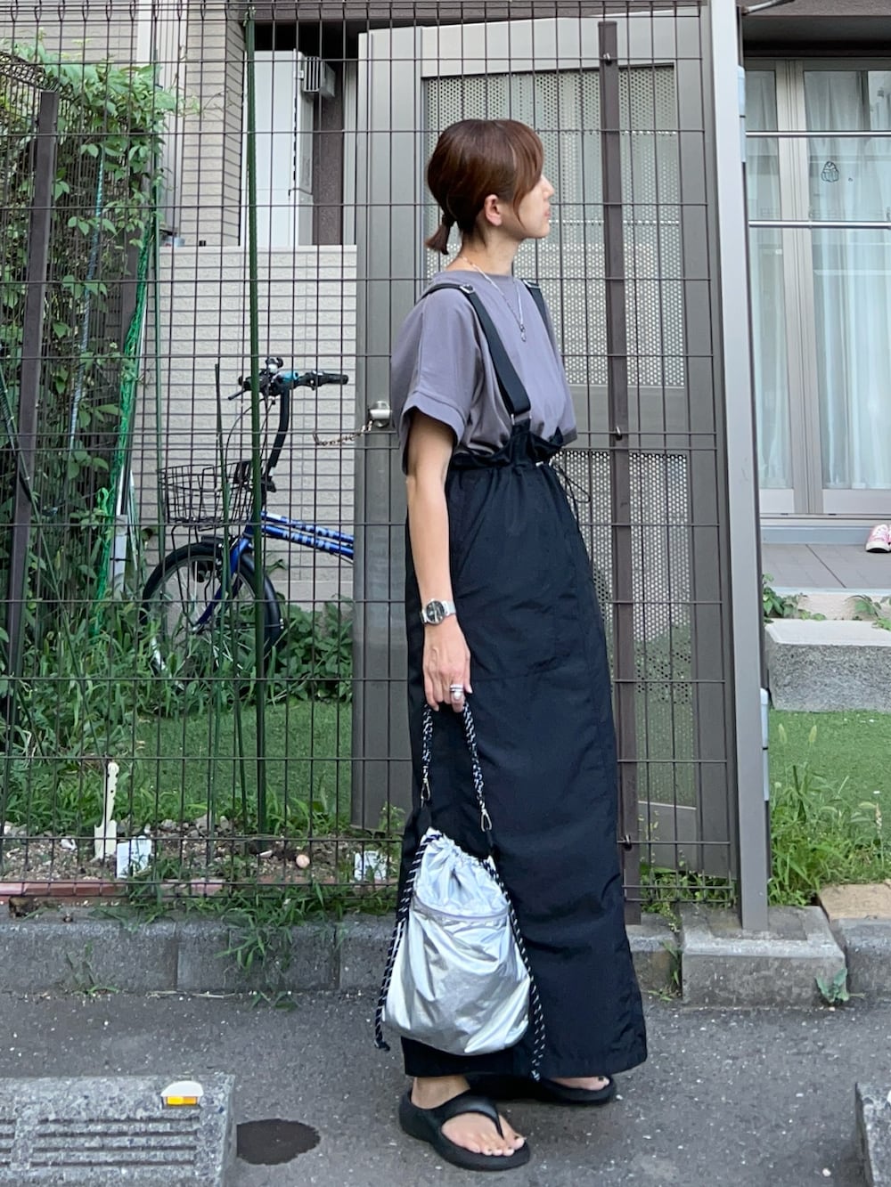 グレー系のTシャツ/カットソー、ブラック系のジャンパースカート、シルバー系のトートバッグを着用したレディースの夏コーディネートの2枚目の写真