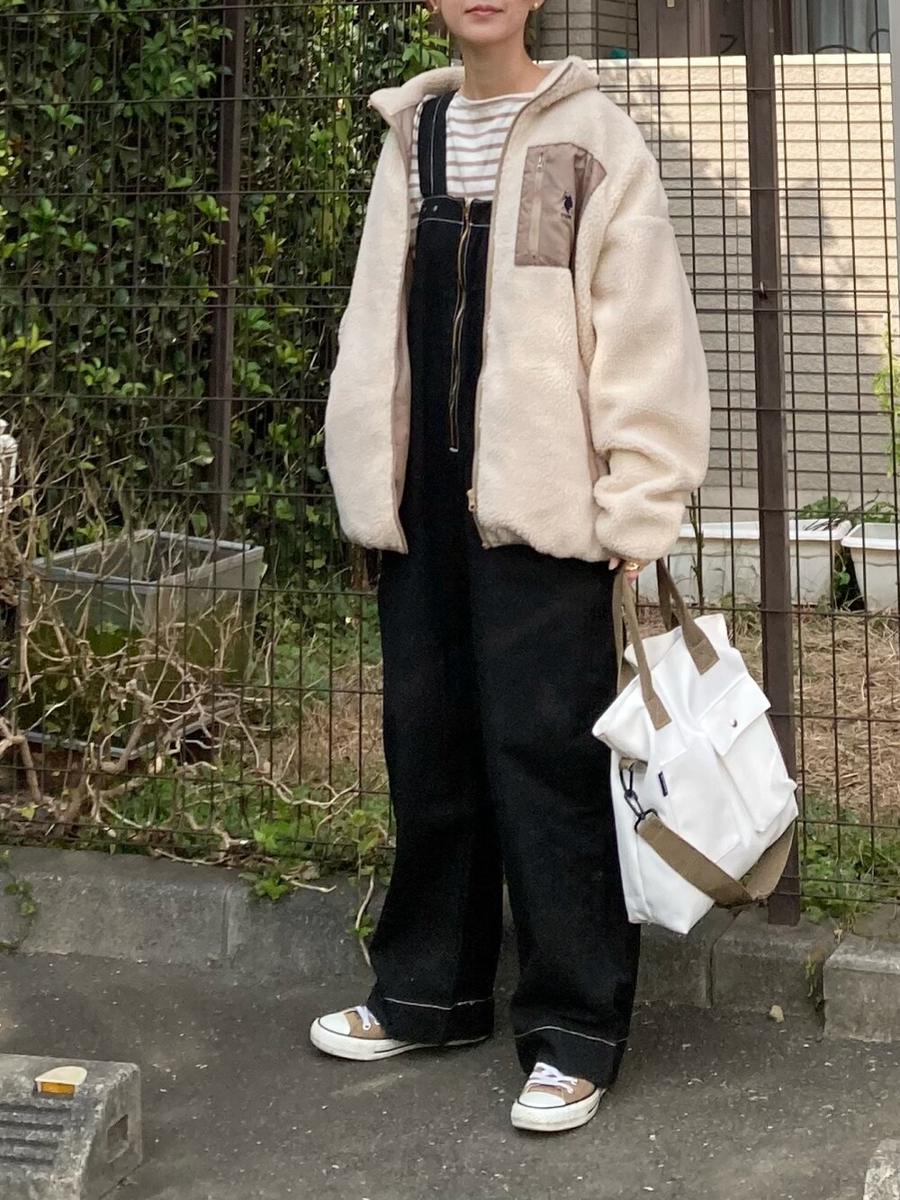 ベージュ系のブルゾン、ベージュ系のTシャツ/カットソー、ブラック系のサロペット/オーバーオールを着用したレディースの秋コーディネートの4枚目の写真