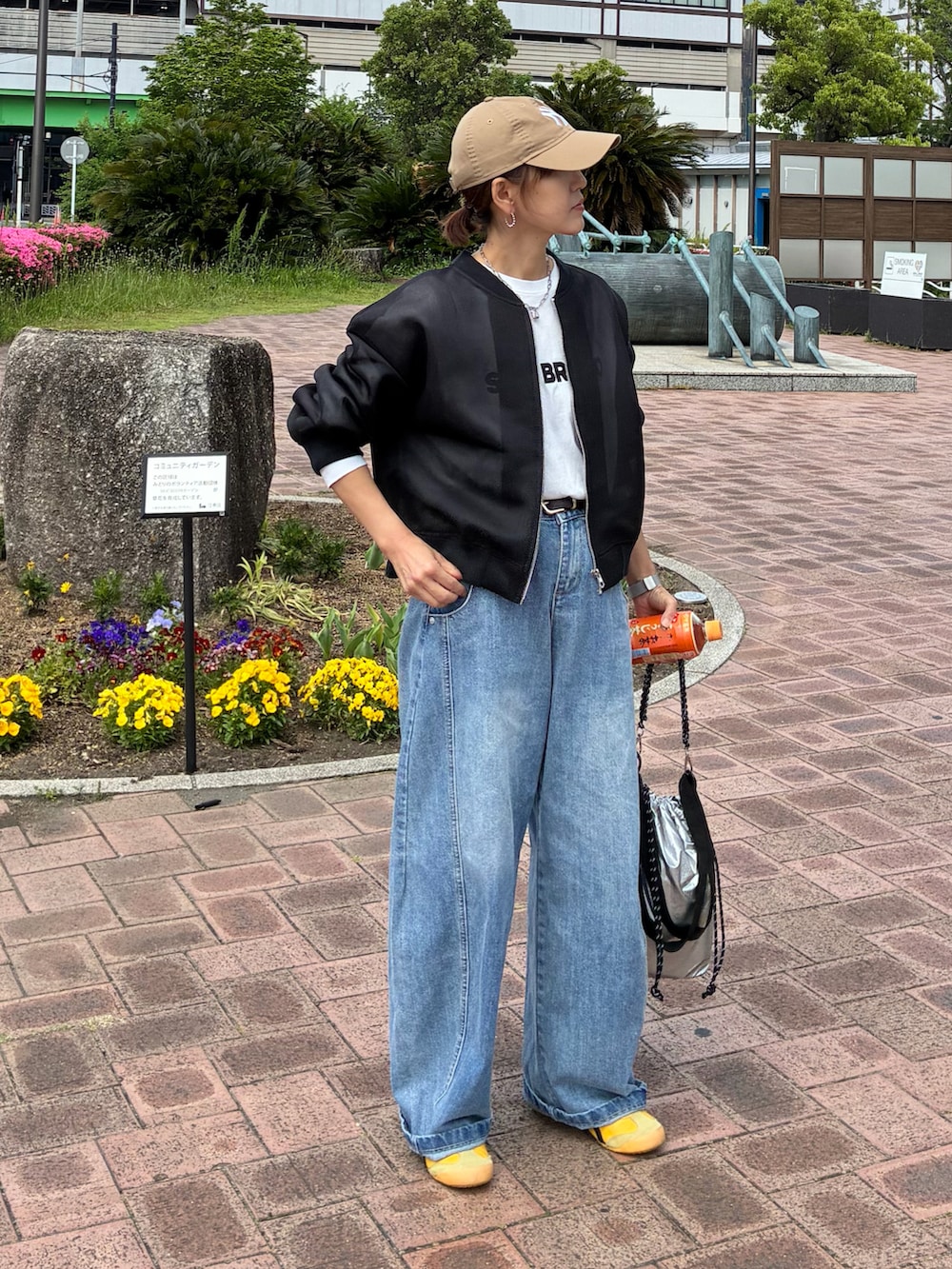 ホワイト系のTシャツ/カットソー、ブラック系のブルゾン、シルバー系のショルダーバッグを着用したレディースの春コーディネートの3枚目の写真