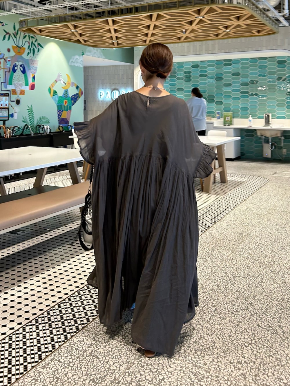 ブラウン系のワンピース、ブルー系のデニムパンツ、シルバー系のショルダーバッグを着用したレディースの夏コーディネートの2枚目の写真
