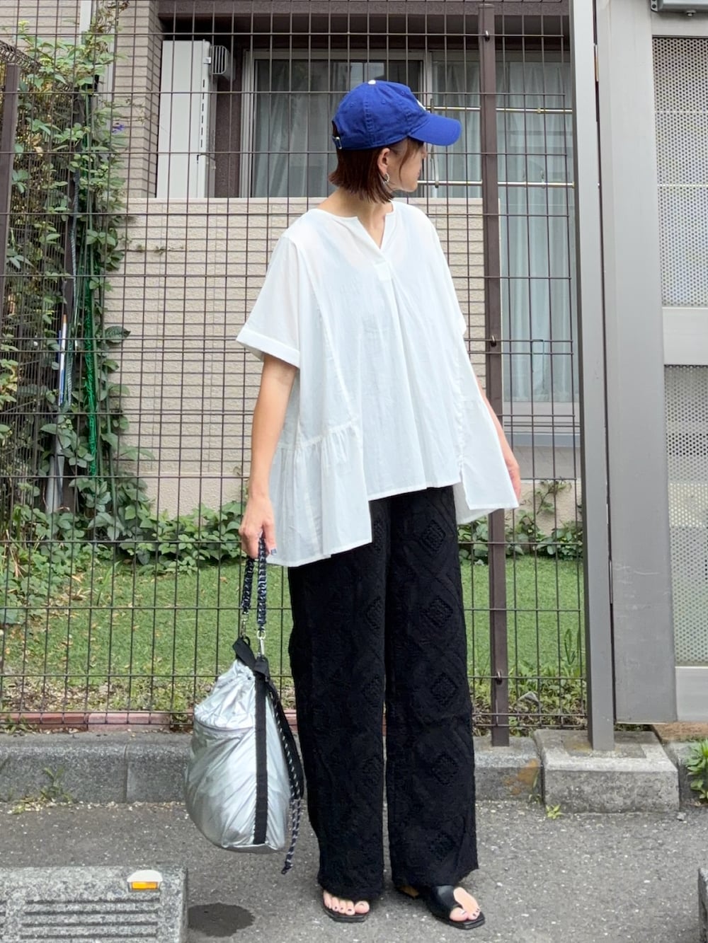 ホワイト系のシャツ/ブラウス、ブラック系のその他パンツ、シルバー系のショルダーバッグを着用したレディースの夏コーディネートの3枚目の写真