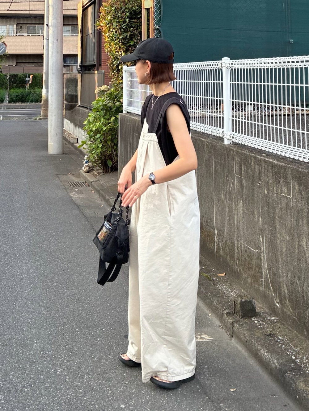 ホワイト系のサロペット/オーバーオール、ブラック系のTシャツ/カットソー、ブラック系のトートバッグを着用したレディースの夏コーディネートの3枚目の写真