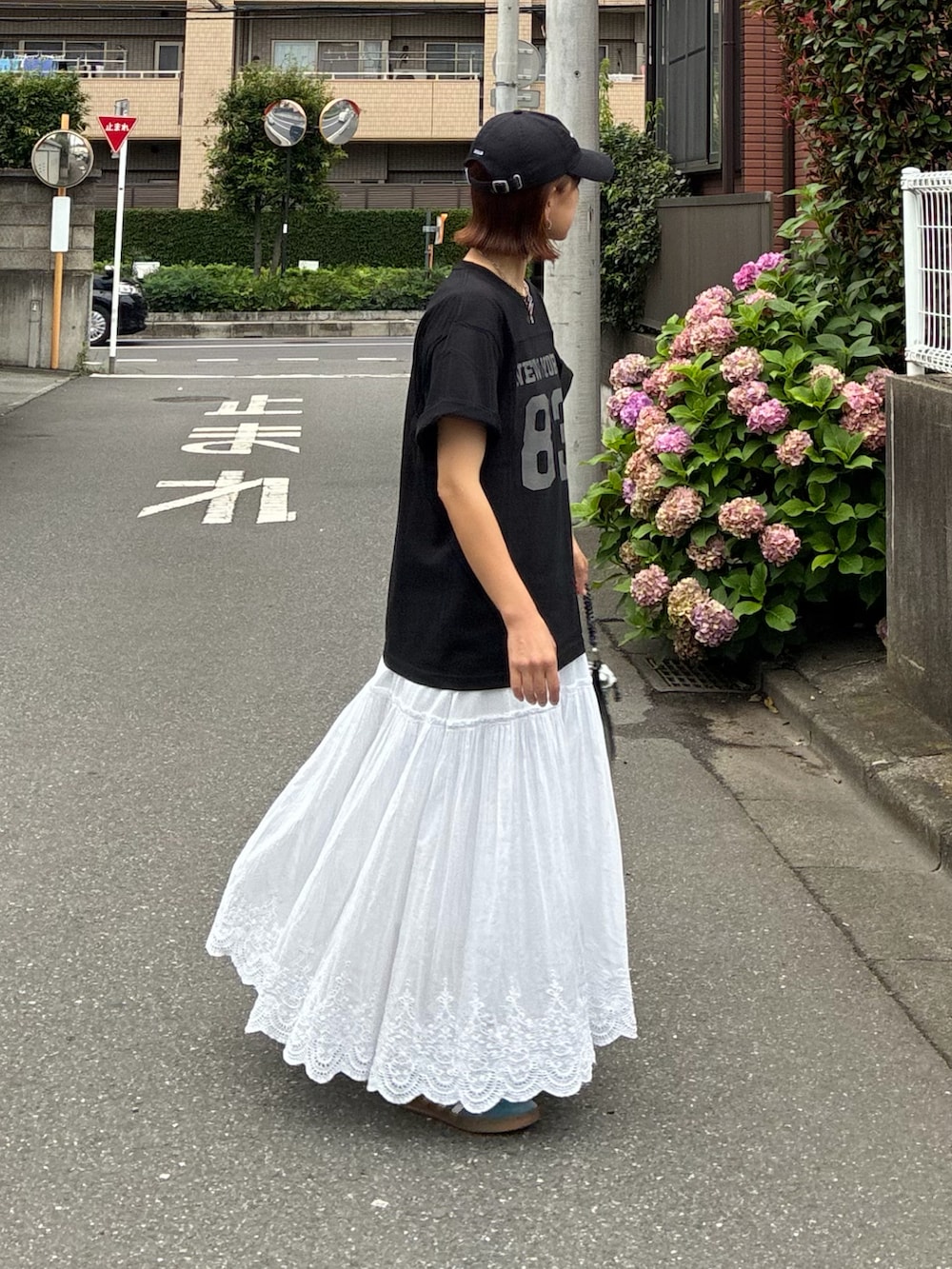 ブラック系のTシャツ/カットソー、ホワイト系のスカート、シルバー系のショルダーバッグを着用したレディースの夏コーディネートの3枚目の写真