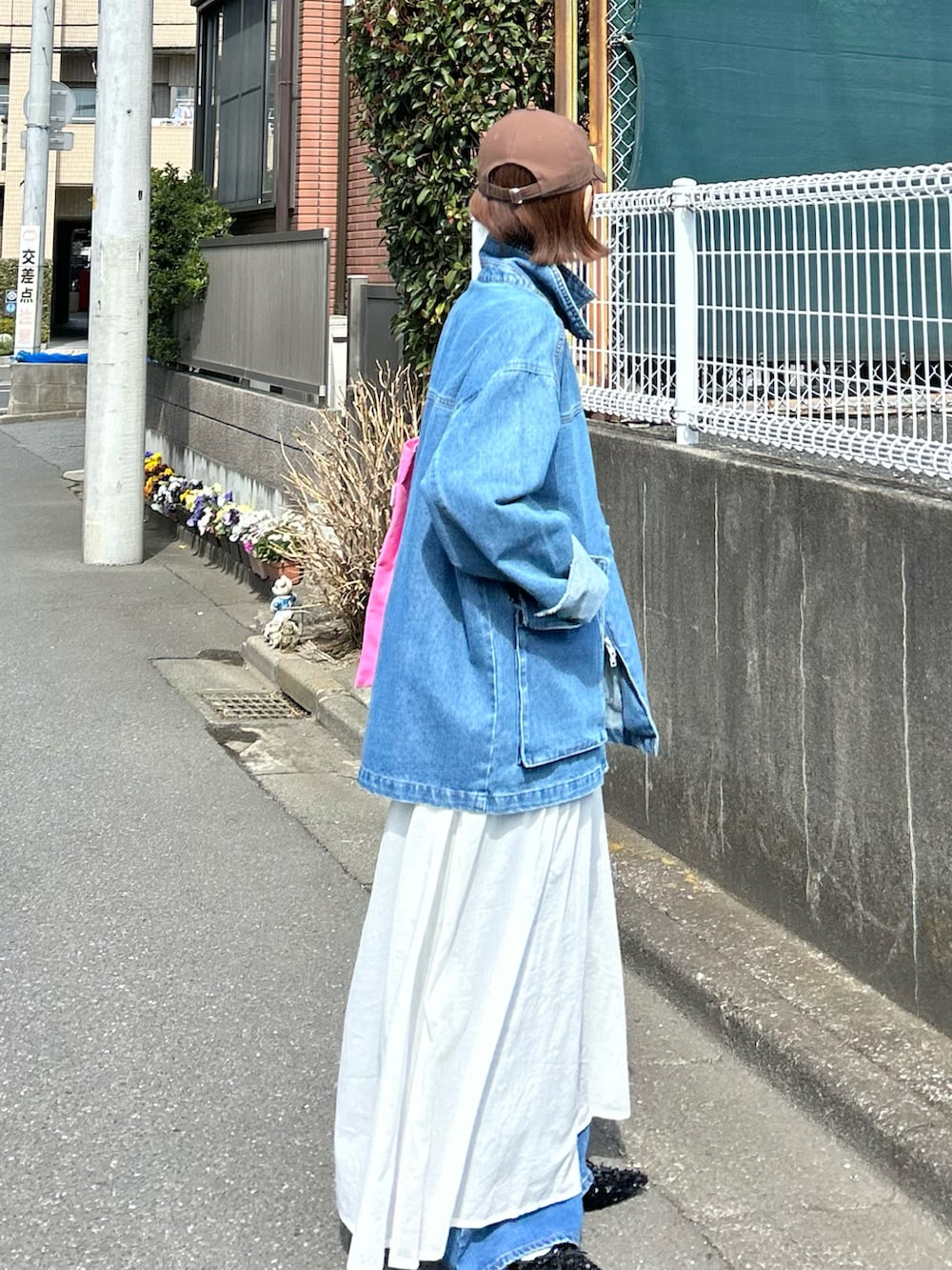 ブルー系のデニムジャケット、ホワイト系のワンピース、ピンク系のトートバッグを着用したレディースの春コーディネートの3枚目の写真