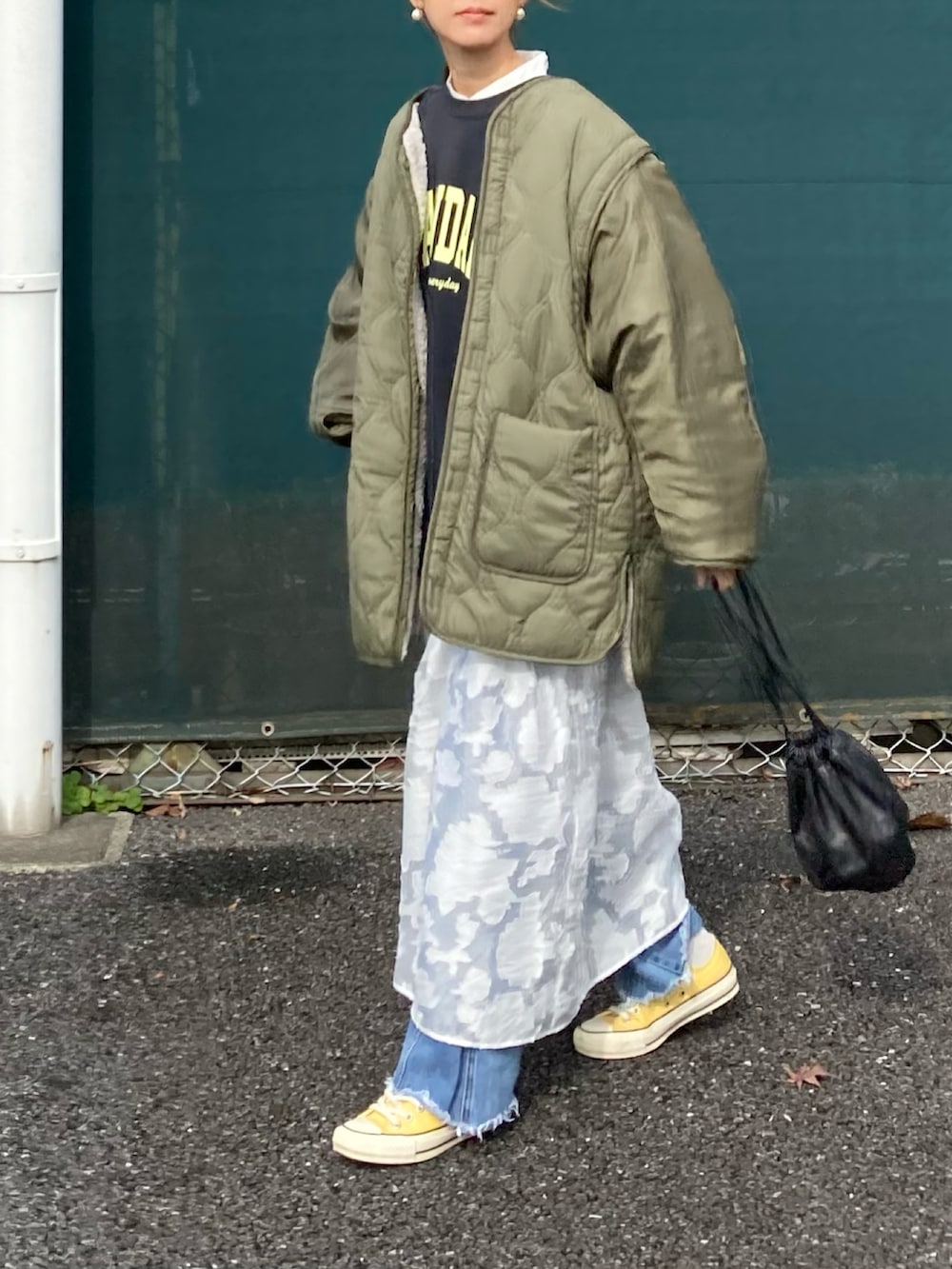 グリーン系のブルゾン、ブラック系のスウェット、ホワイト系のワンピースを着用したレディースの冬コーディネートの2枚目の写真