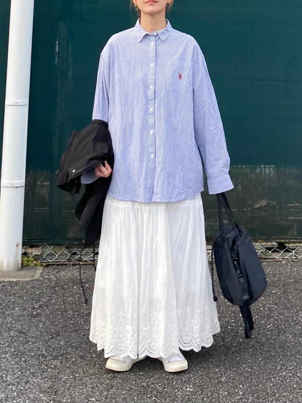 ブラック系のベスト、ブルー系のシャツ/ブラウス、ホワイト系のスカートを着用したレディースの冬コーディネートの3枚目の写真