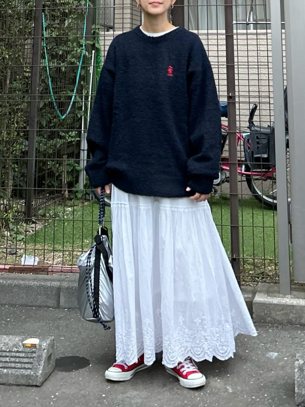 ブルー系のニット/セーター、シルバー系のトートバッグ、ホワイト系のスカートを着用したレディースの秋コーディネートの2枚目の写真