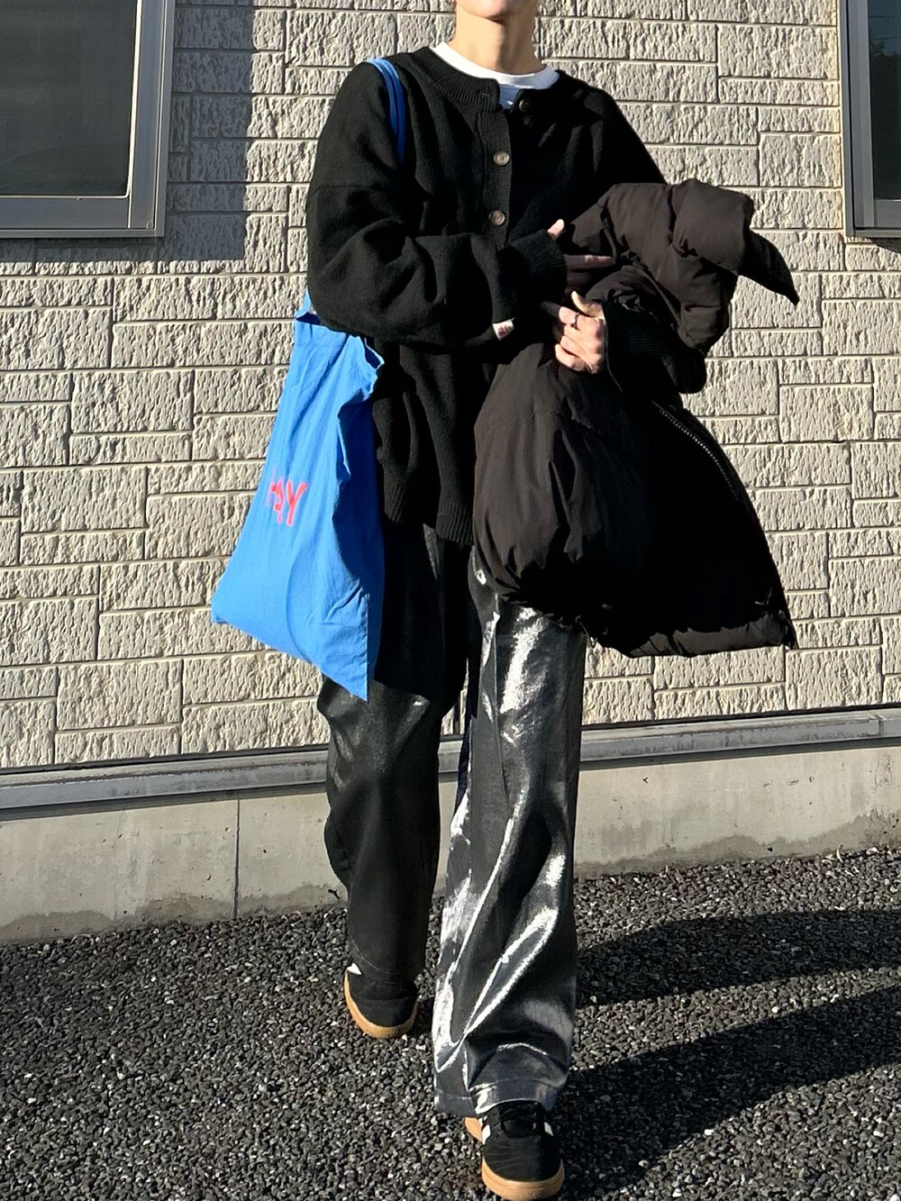 ブラック系のニット/セーター、ブラック系のその他パンツ、ブルー系のトートバッグを着用したレディースの春コーディネートの5枚目の写真