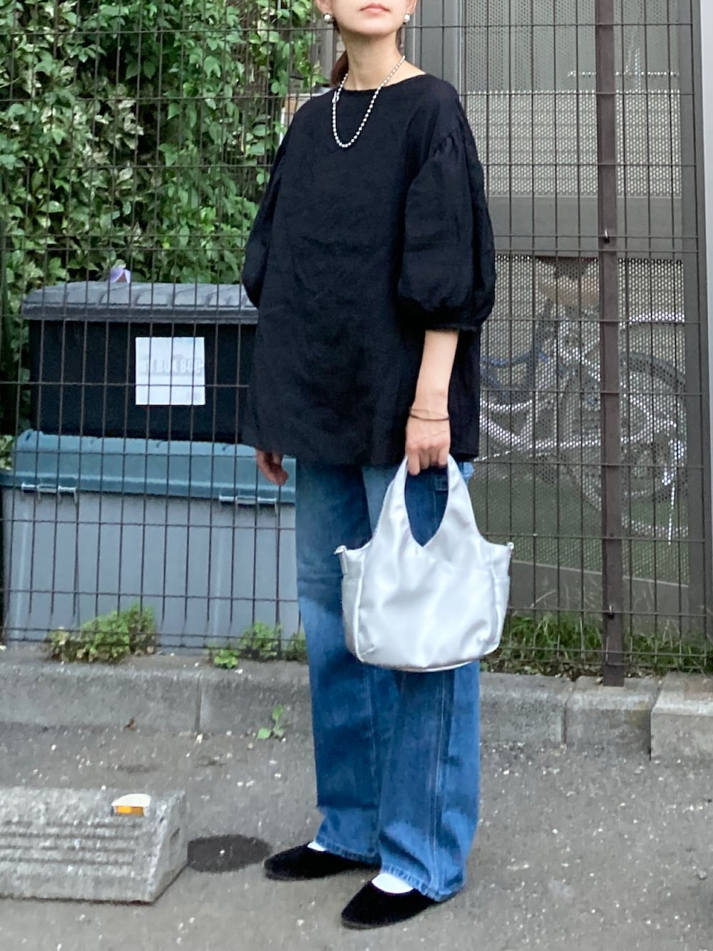 ブラック系のシャツ/ブラウス、ブルー系のデニムパンツ、シルバー系のショルダーバッグを着用したレディースの秋コーディネートの2枚目の写真