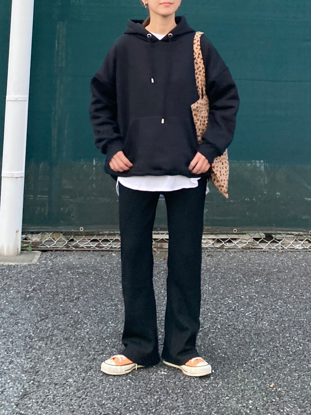 ブラック系のパーカー、ブラック系のその他パンツ、イエロー系のトートバッグを着用したレディースの秋コーディネートの4枚目の写真