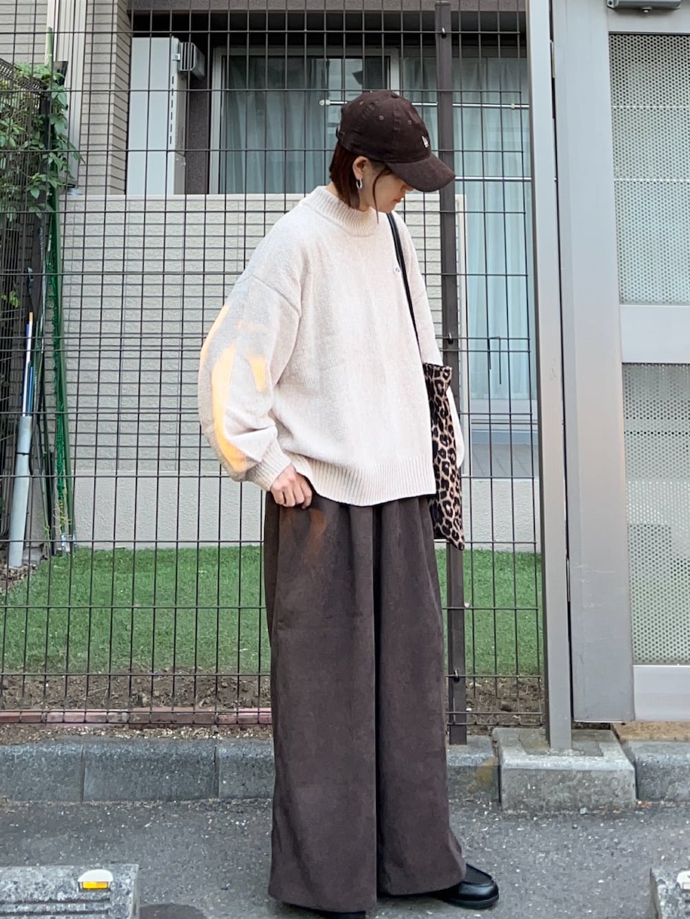 ベージュ系のニット/セーター、ブラウン系のスラックス、ブラウン系のトートバッグを着用したレディースの秋コーディネートの2枚目の写真