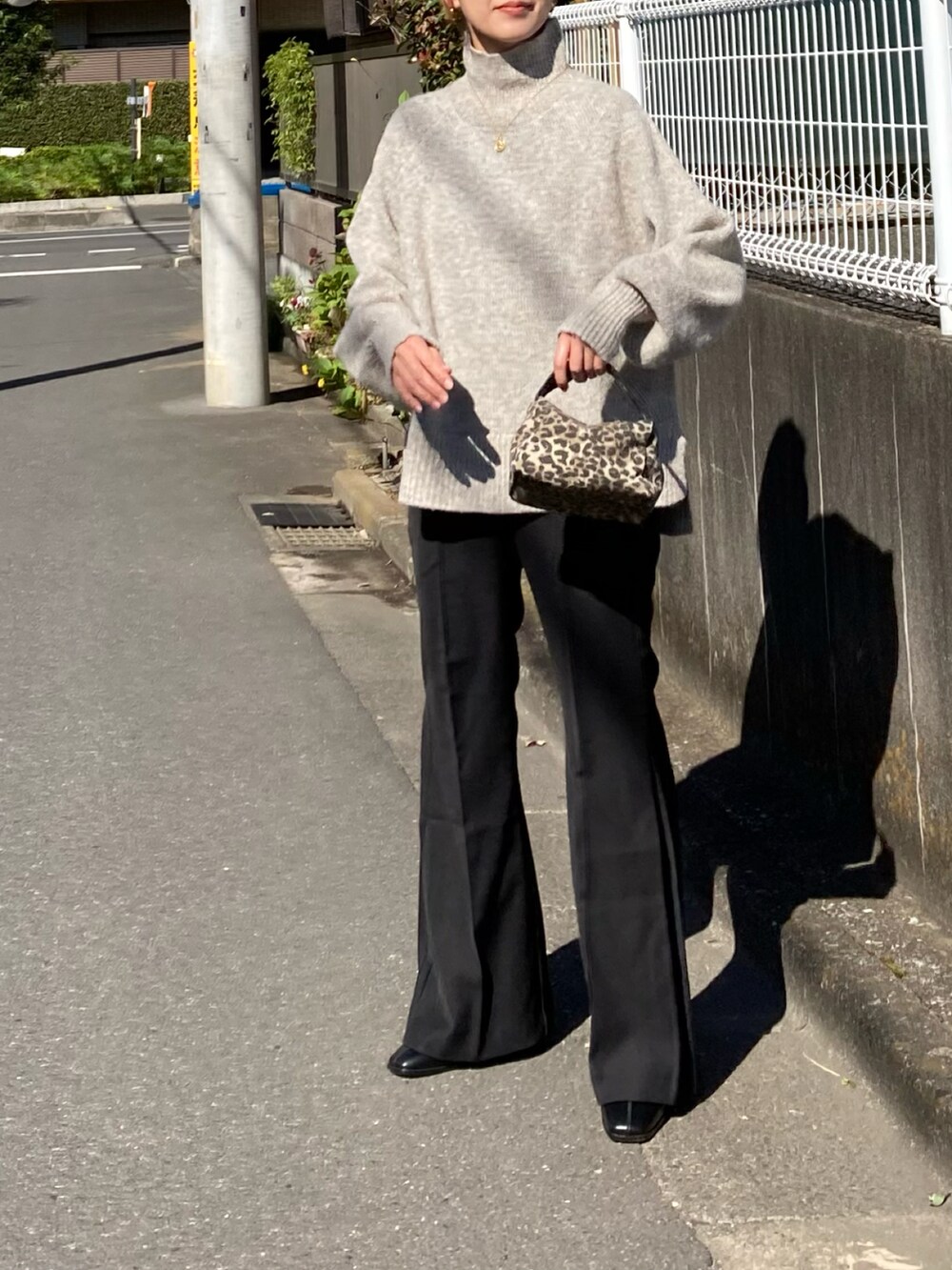 ホワイト系のニット/セーター、ブラック系のその他パンツ、ブラック系のブーツを着用したレディースの秋コーディネートの2枚目の写真