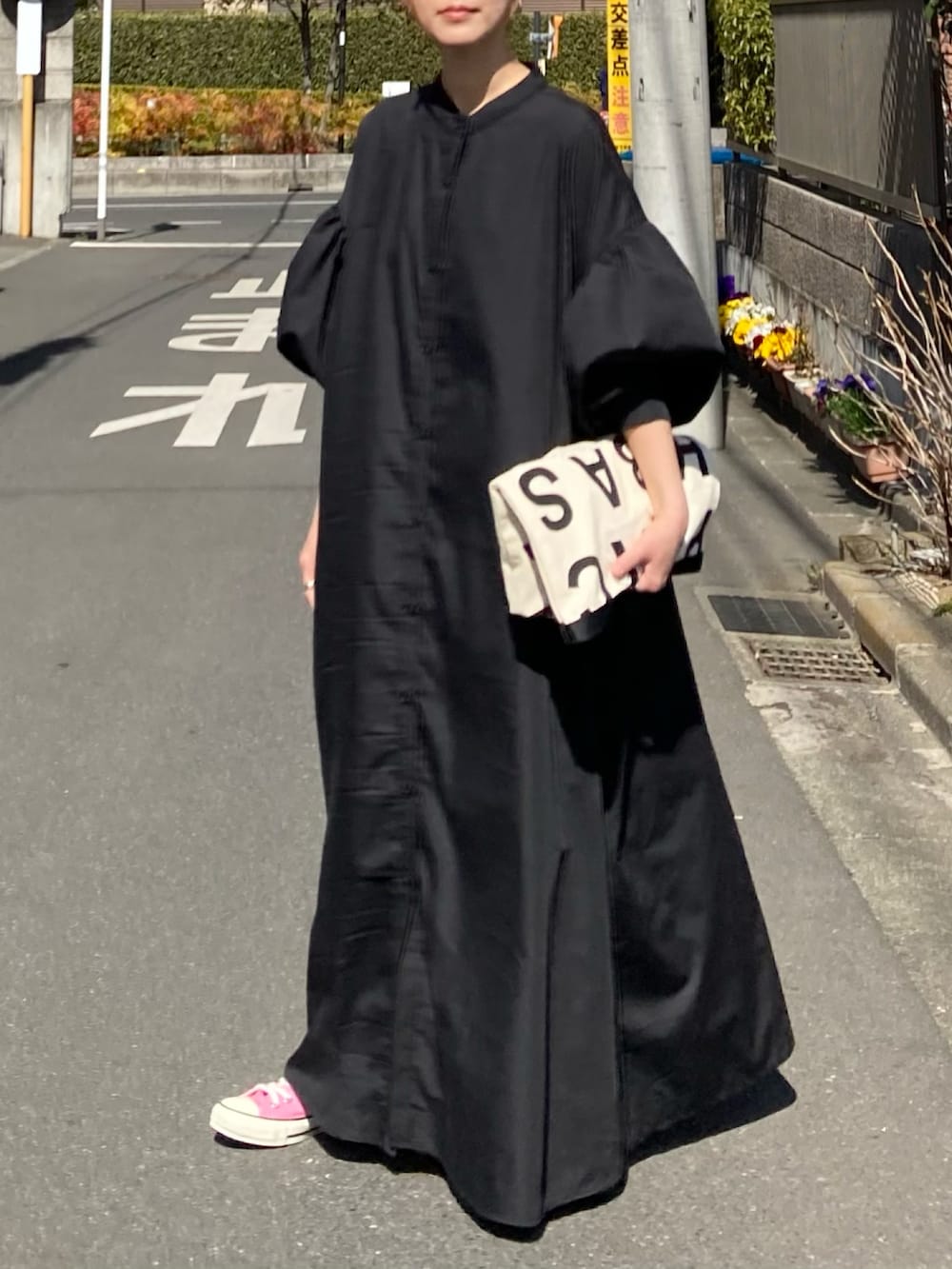 ブラック系のワンピース、ホワイト系のトートバッグ、レッド系のスニーカーを着用したレディースの春コーディネートの4枚目の写真