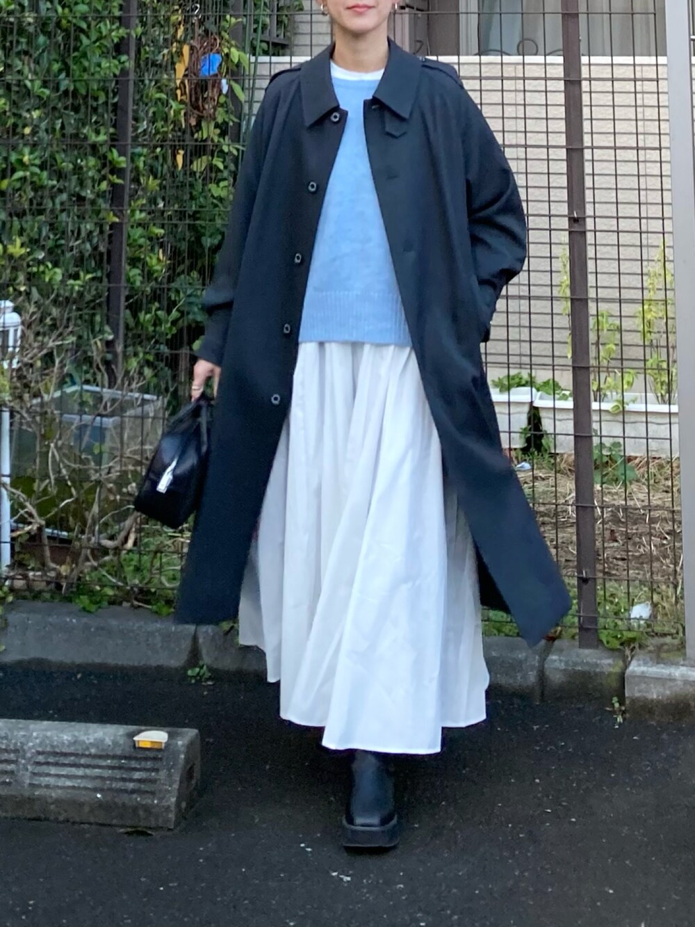 グレー系のその他アウター、ブルー系のニット/セーター、ホワイト系のシャツワンピースを着用したレディースの冬コーディネートの2枚目の写真