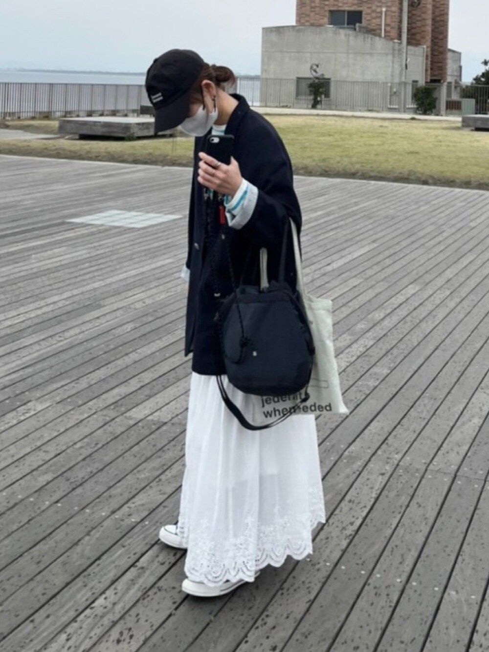 ブルー系のテーラードジャケット、ブルー系のTシャツ/カットソー、ホワイト系のスカートを着用したレディースの春コーディネートの3枚目の写真