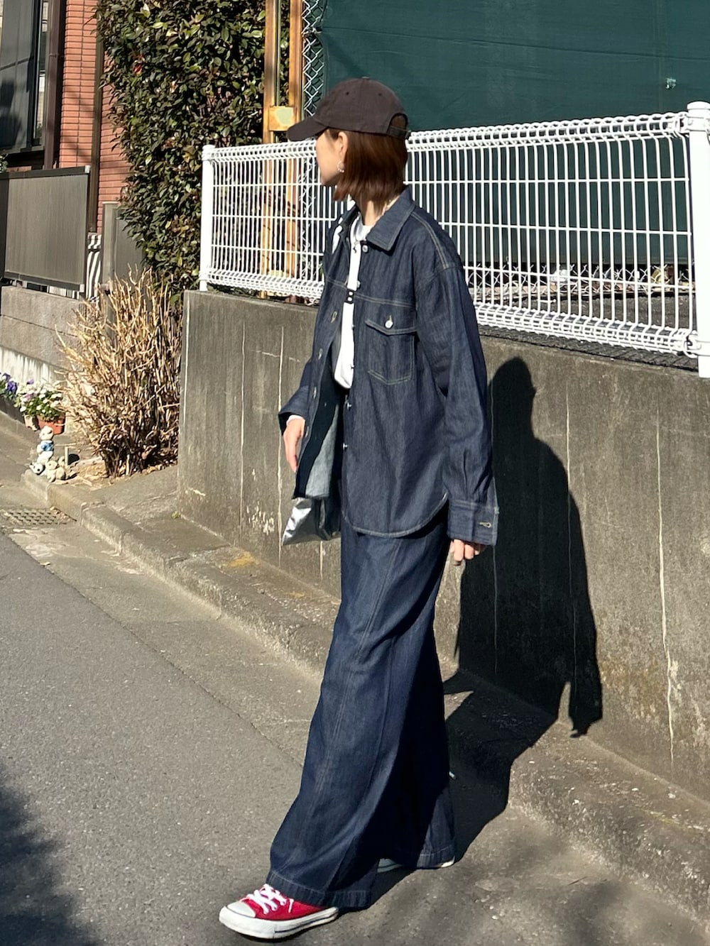 ブルー系のシャツ/ブラウス、ホワイト系のTシャツ/カットソー、シルバー系のクラッチバッグを着用したレディースの冬コーディネートの3枚目の写真