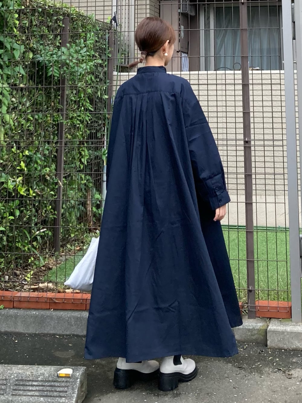 ブルー系のシャツワンピース、ホワイト系のブーツ、ゴールド系のピアス（両耳用）を着用したレディースの秋コーディネートの3枚目の写真