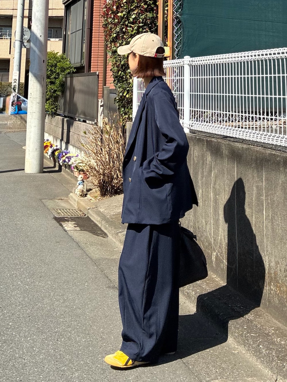 ブルー系のテーラードジャケット、ブルー系のスラックス、ブラウン系のトートバッグを着用したレディースの春コーディネートの3枚目の写真