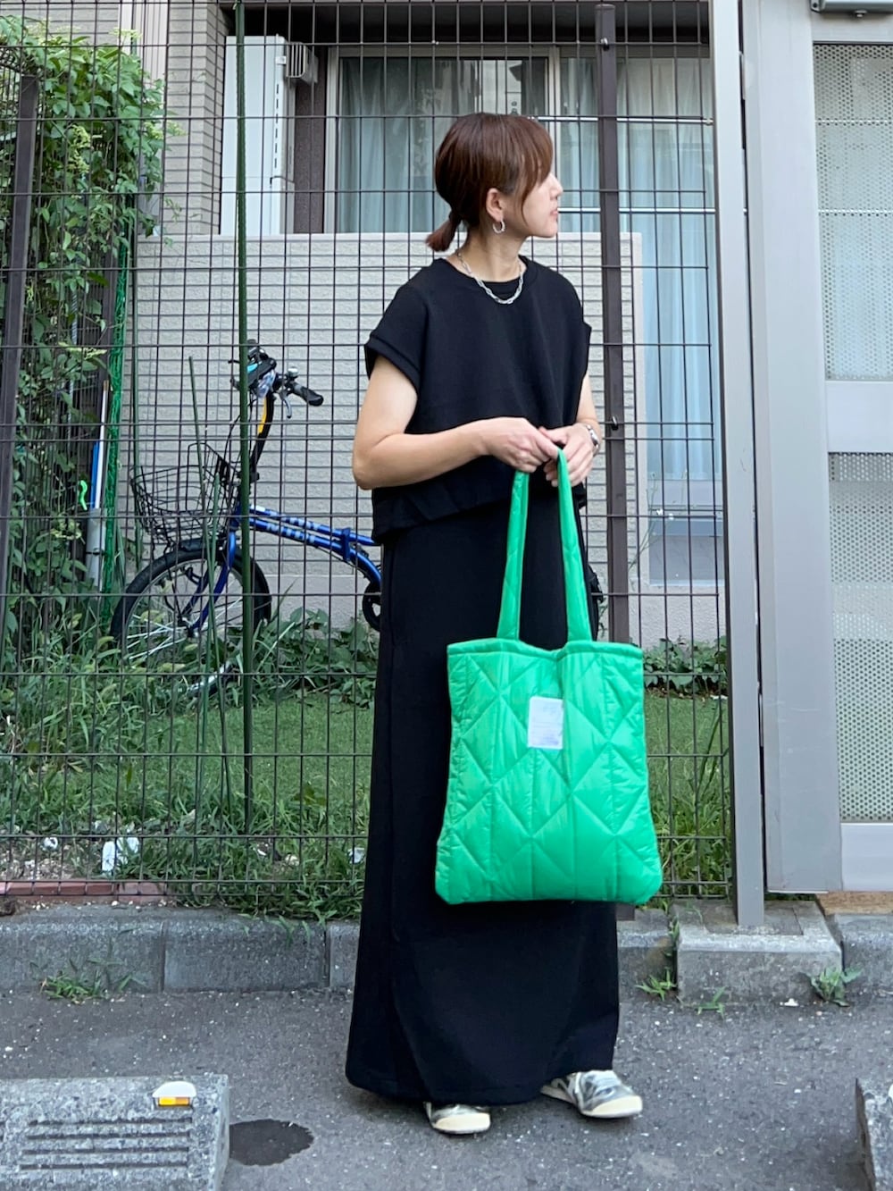 ブラック系のジャンパースカート、グリーン系のトートバッグ、シルバー系のスニーカーを着用したレディースの夏コーディネートの3枚目の写真