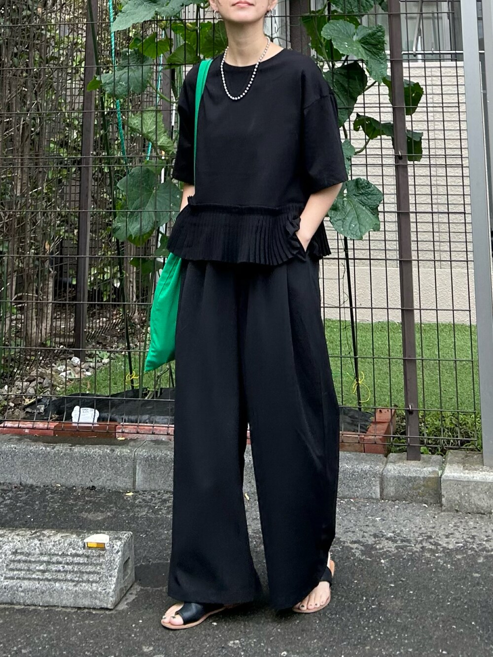 ブラック系のTシャツ/カットソー、ブラック系のその他パンツ、グリーン系のトートバッグを着用したレディースの夏コーディネートの3枚目の写真