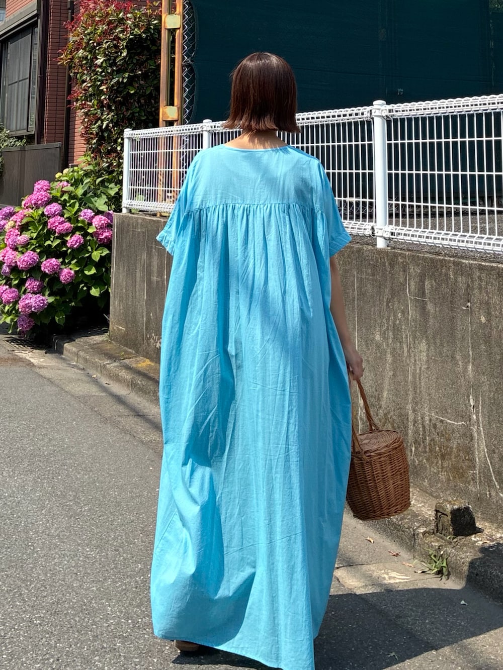ブルー系のワンピース、ブルー系のデニムパンツを着用したレディースの夏コーディネートの4枚目の写真