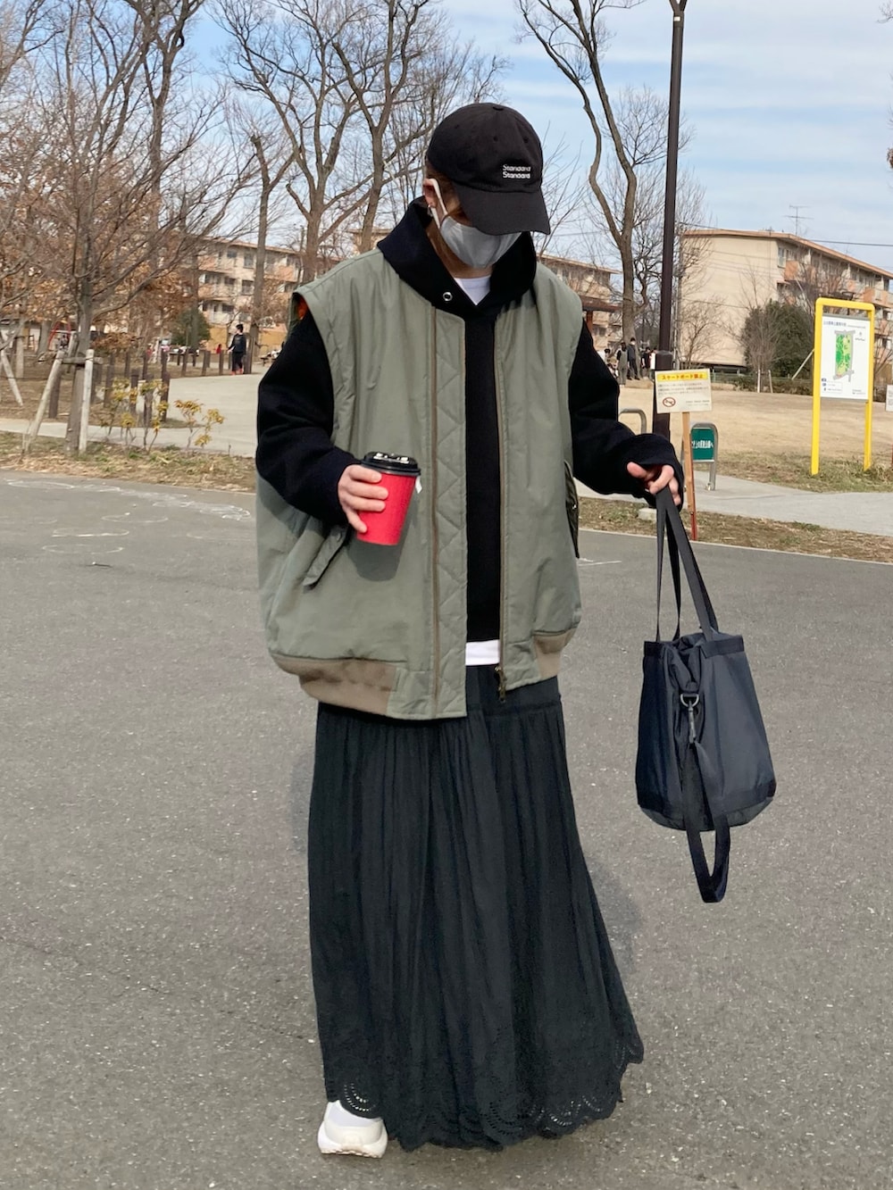 グリーン系のMA-1、ブラック系のパーカー、ブラック系のスカートを着用したレディースの春コーディネートの2枚目の写真